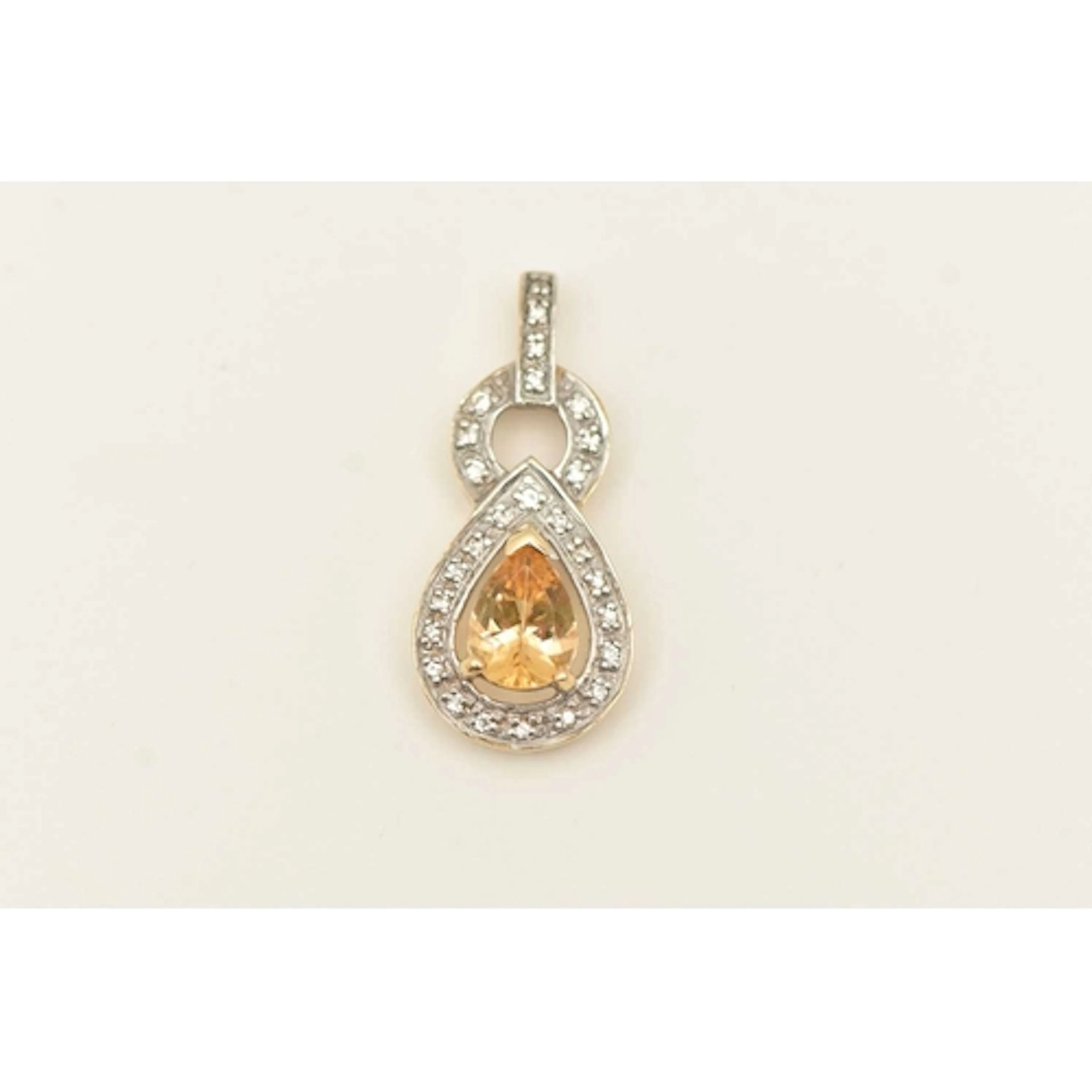 A 9CT GOLD GEM SET PENDANT, a pear cut imperial topaz set wi...