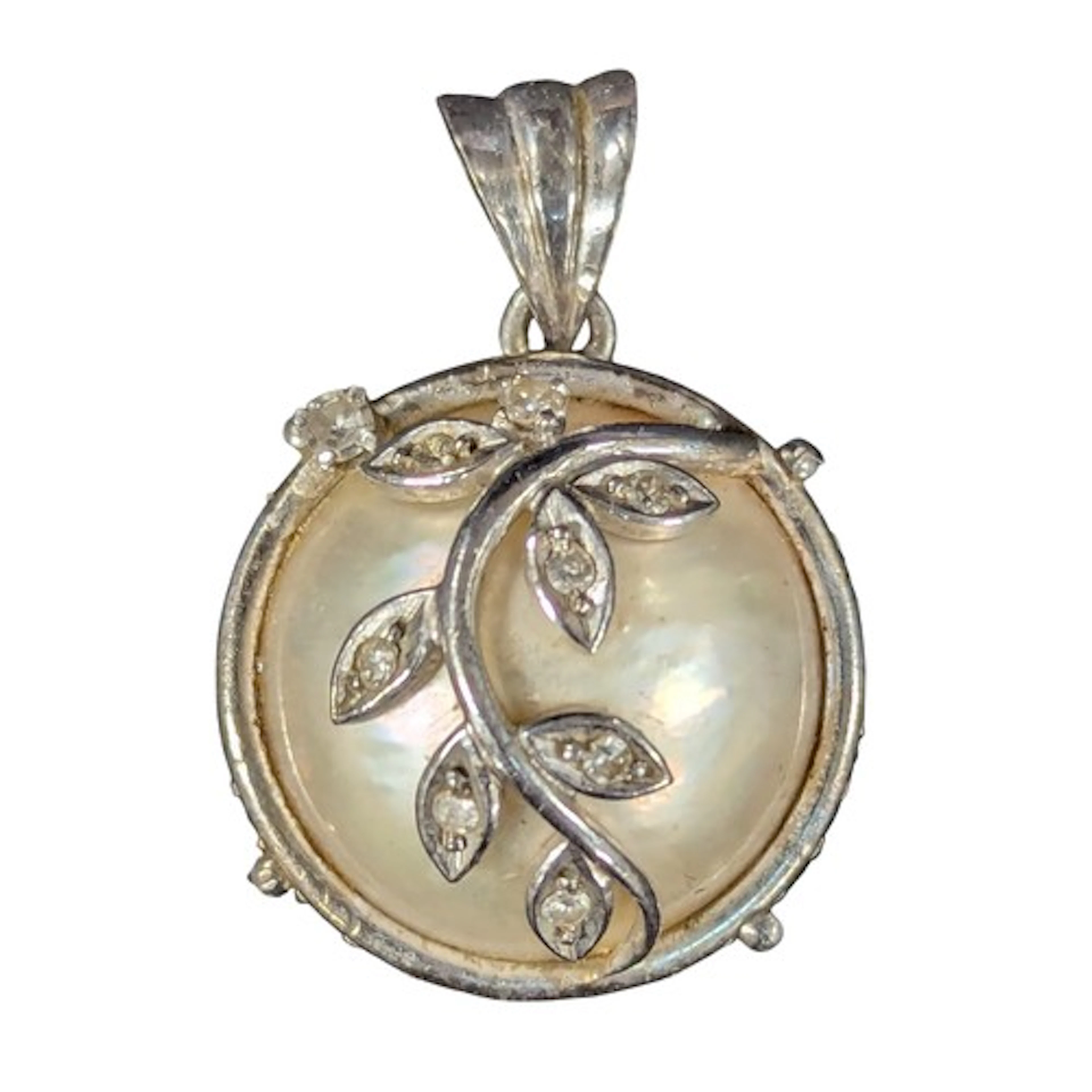 A white metal mounted mother of pearl, diamond and white sap...