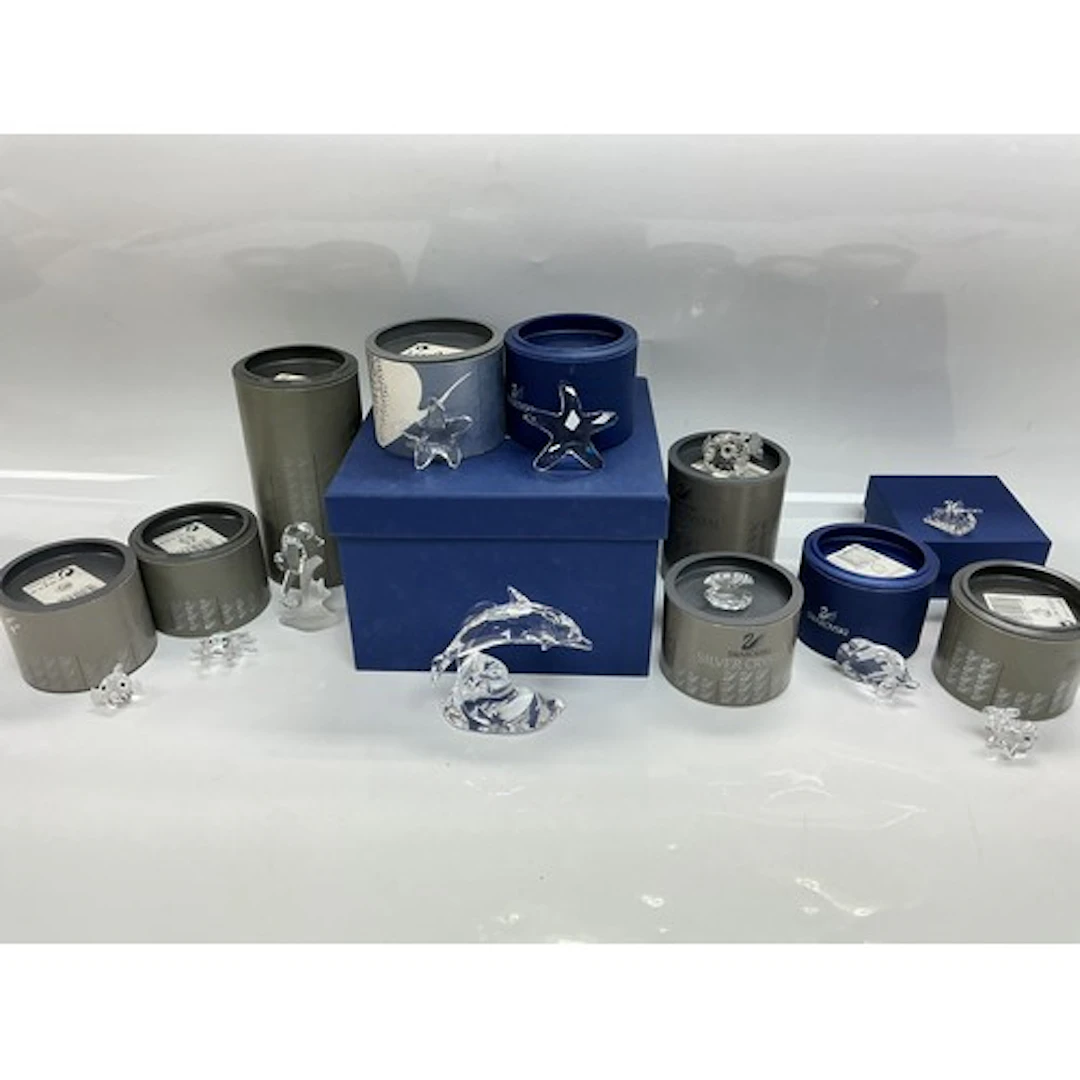 A collection of boxed Swarovski figures of fish and other se...