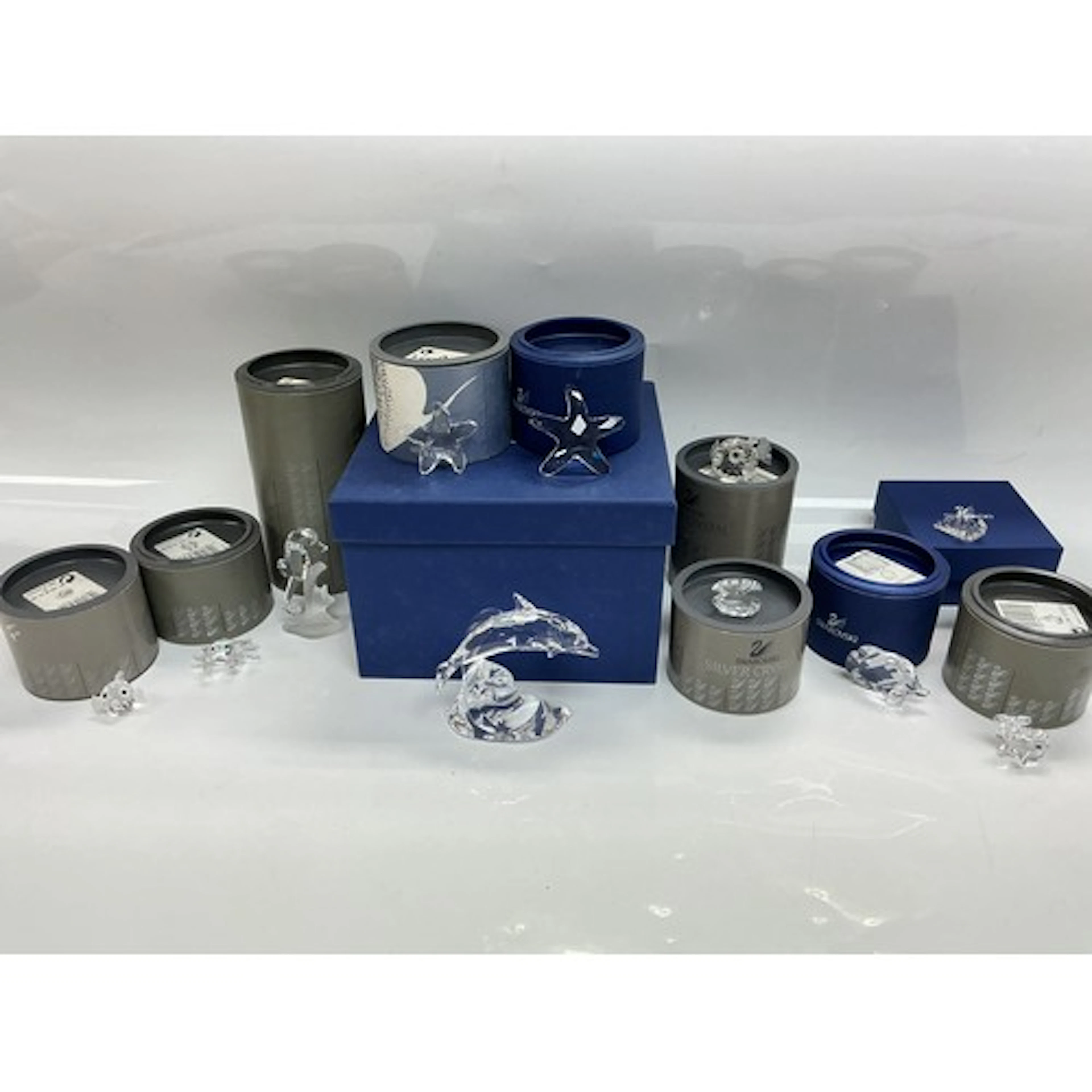 A collection of boxed Swarovski figures of fish and other se...
