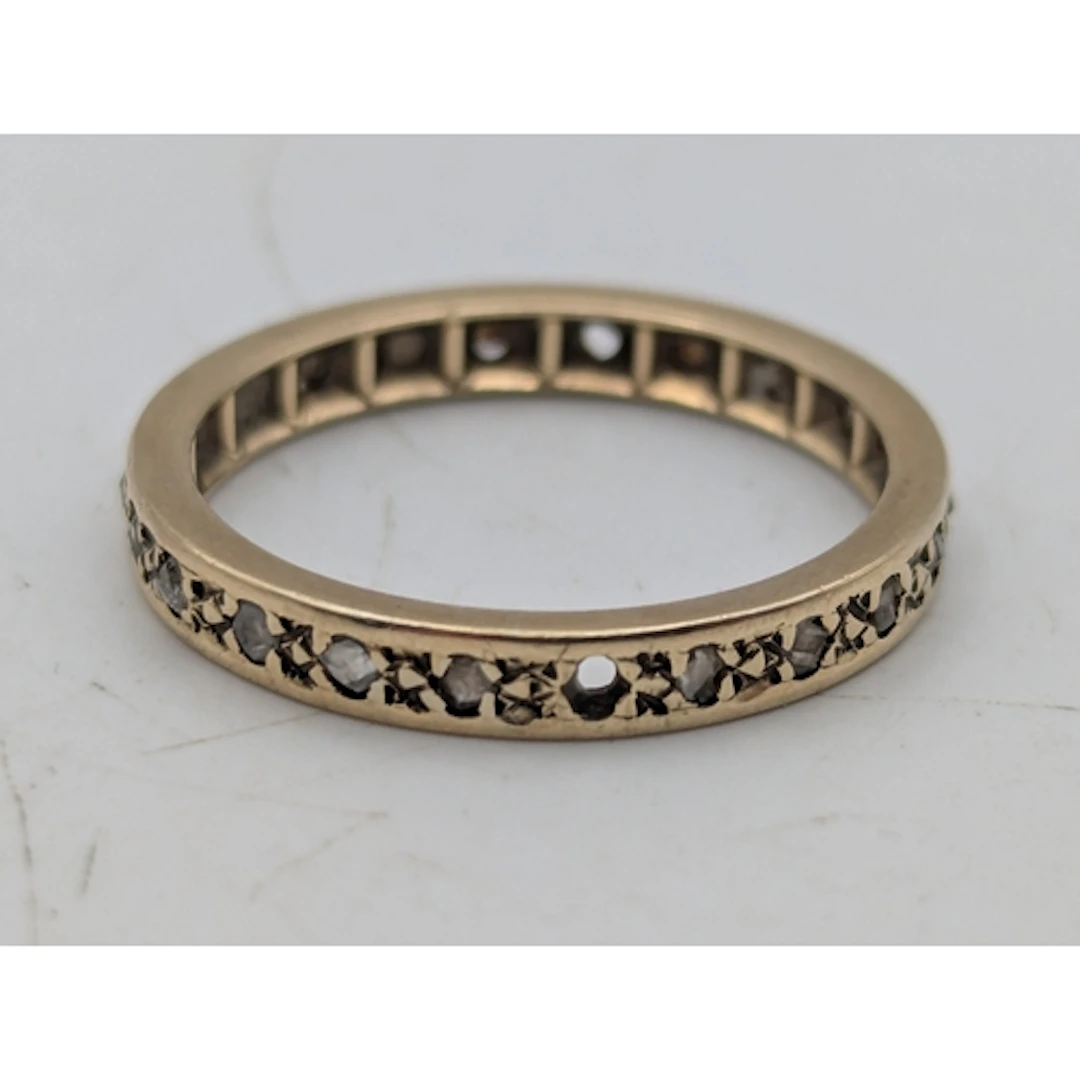 A diamond and yellow metal full eternity ring, two stones mi...