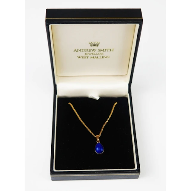 A lapis lazuli teardrop pendant in a 9ct yellow gold setting...