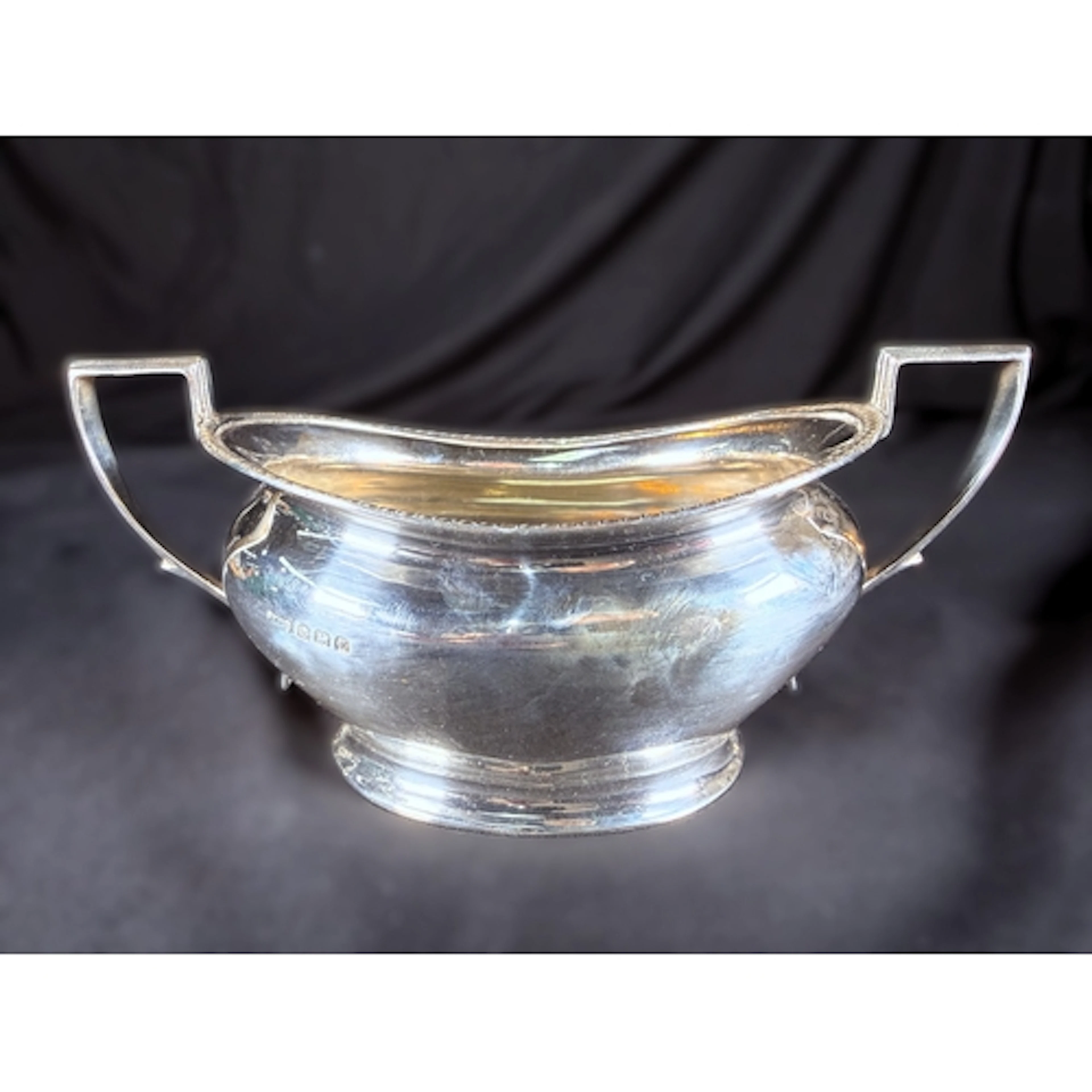 A hall marked silver two handled sugar bowl with gadrooned e...