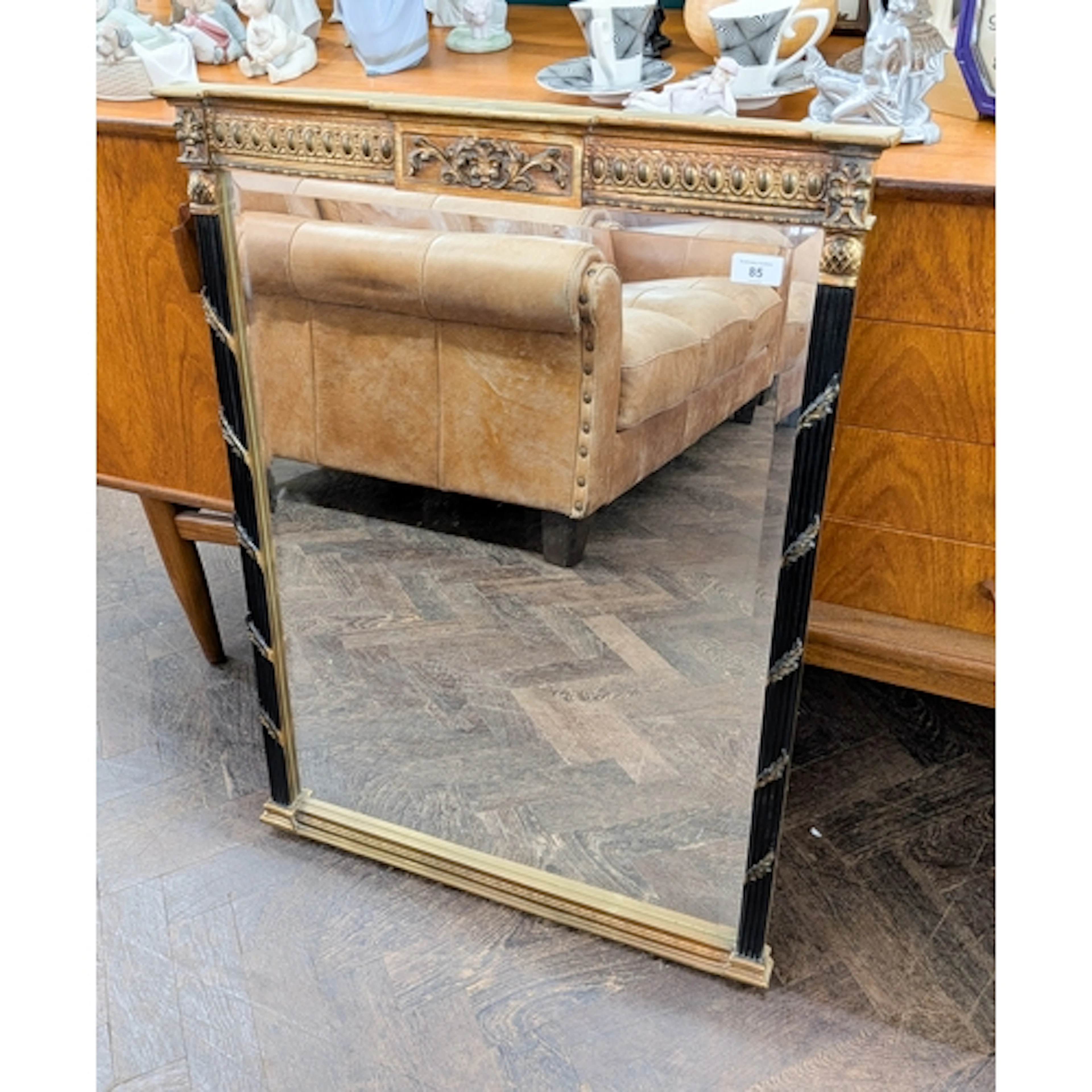 A bevelled wall mirror in decorative gilt and black frame