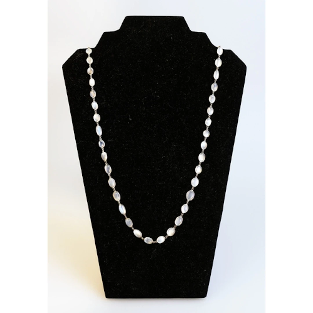 A graduated moonstone bead necklace in a white metal setting...