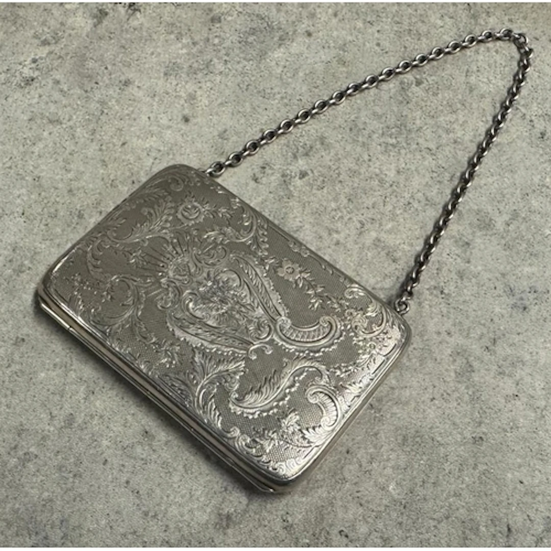 An engraved Victorian silver card holder with engraved decor...