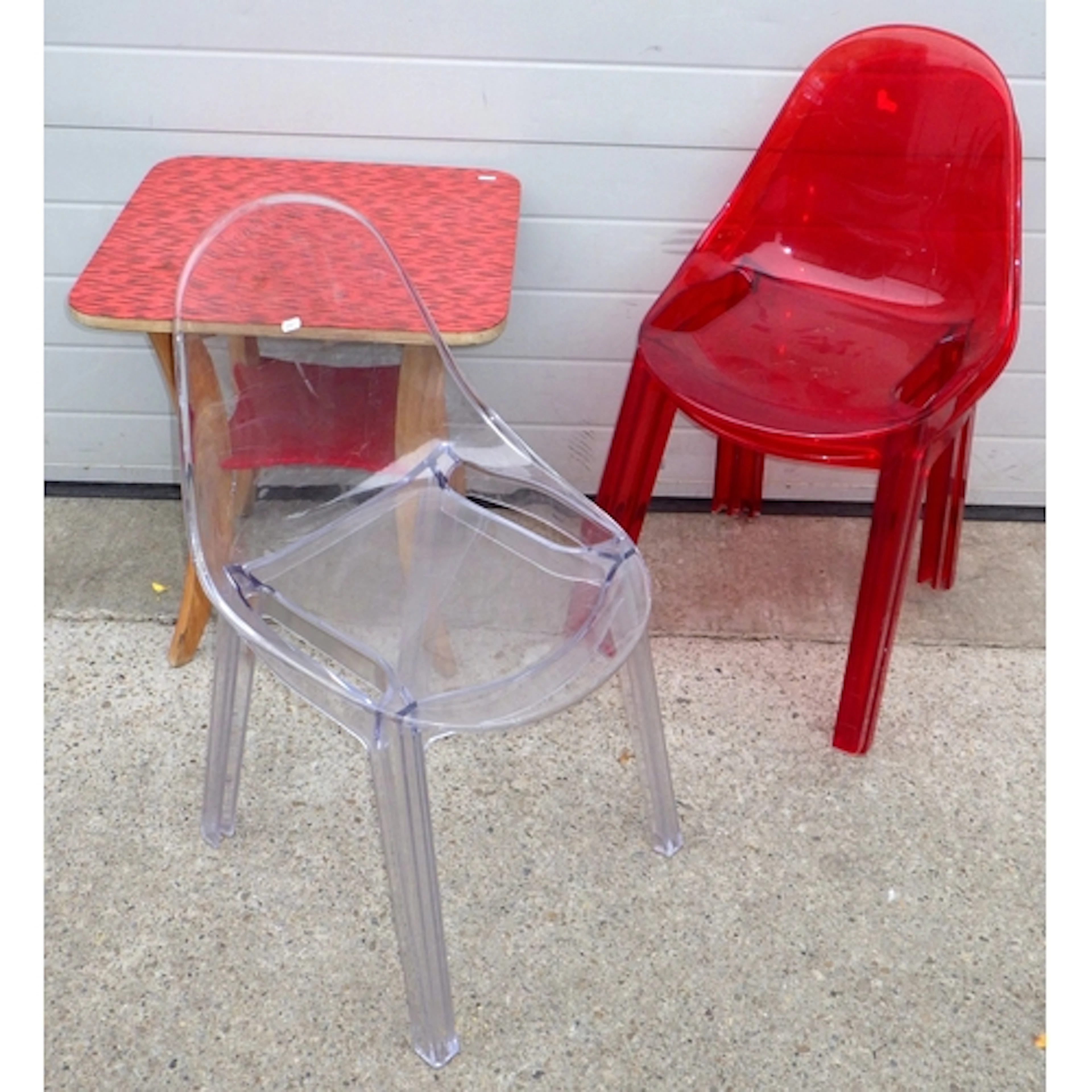 Two red plastic stacking chairs, a clear plastic stacking ch...