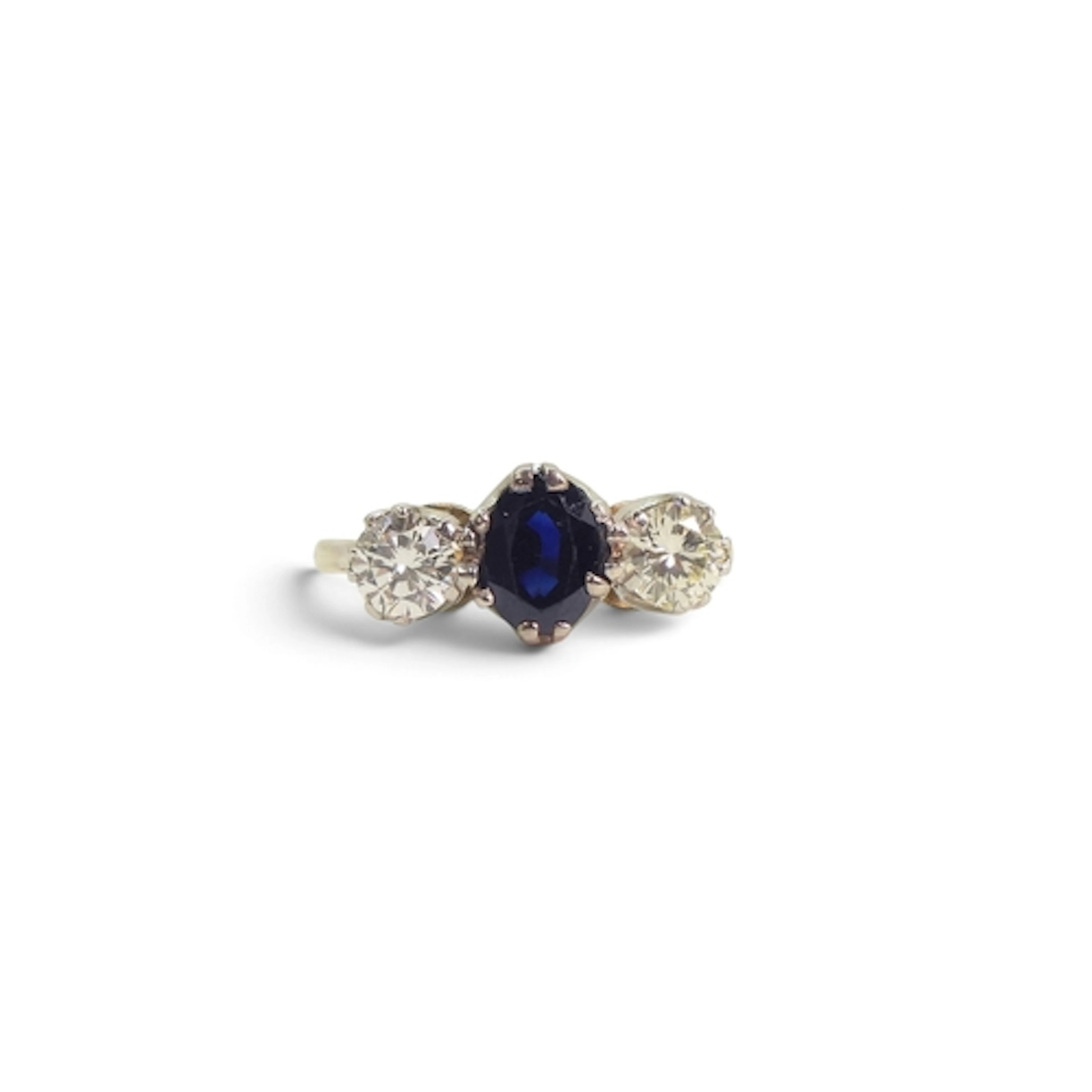 A sapphire and diamond thee stone ring set with an oval sapp...