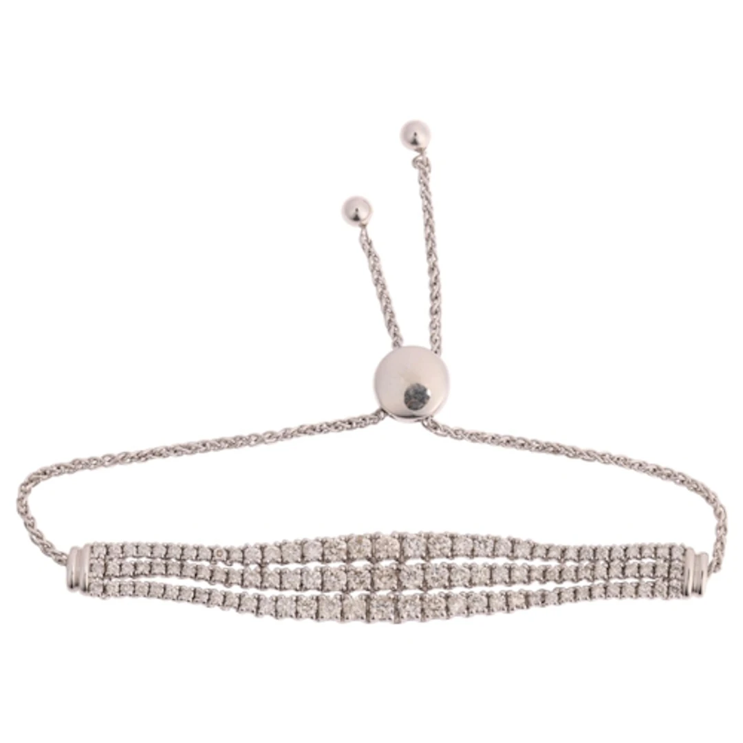 A 9ct white gold diamond triple-line bracelet, maker JST, ea...