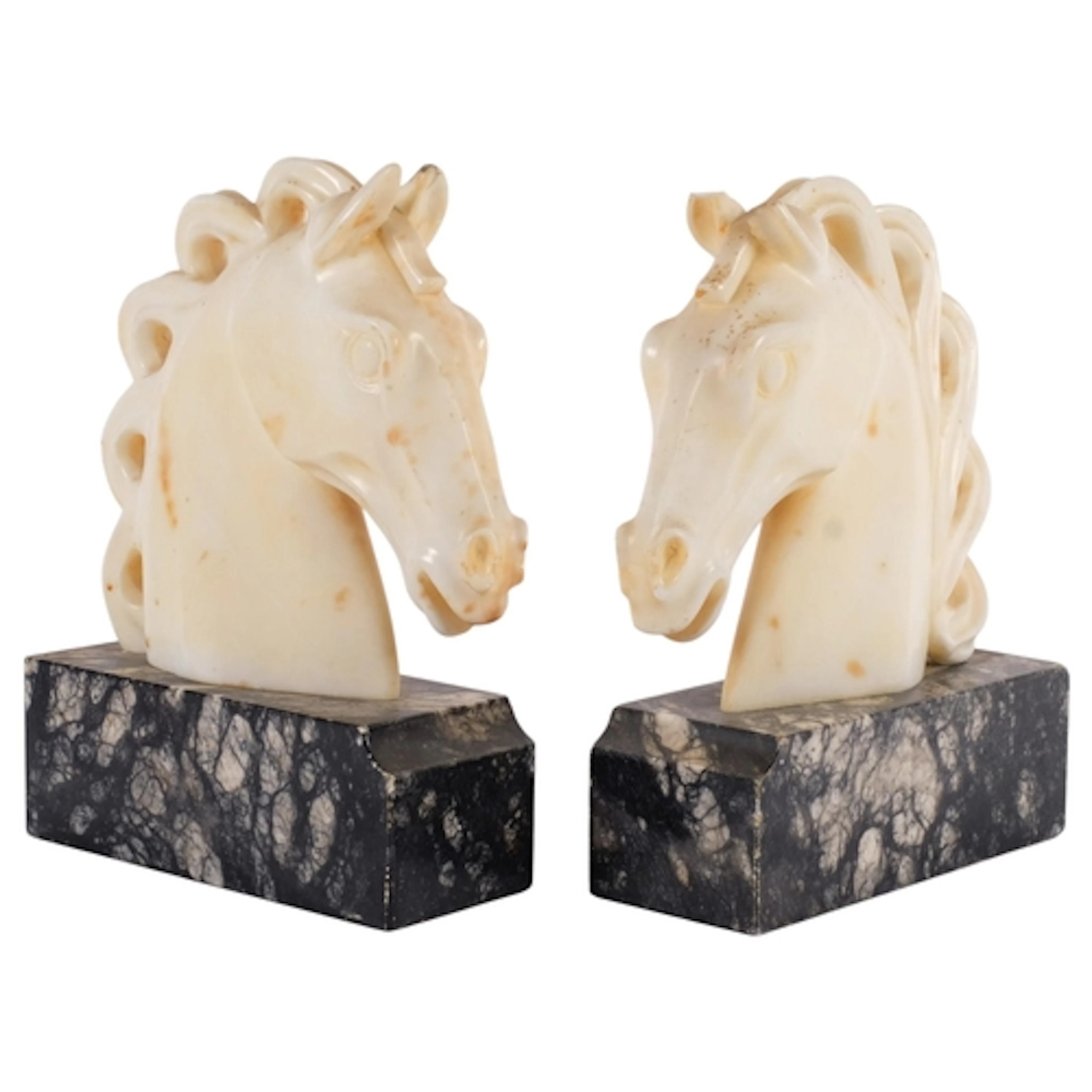 A pair of carved marble horse-head sculptures, on plinths, H...