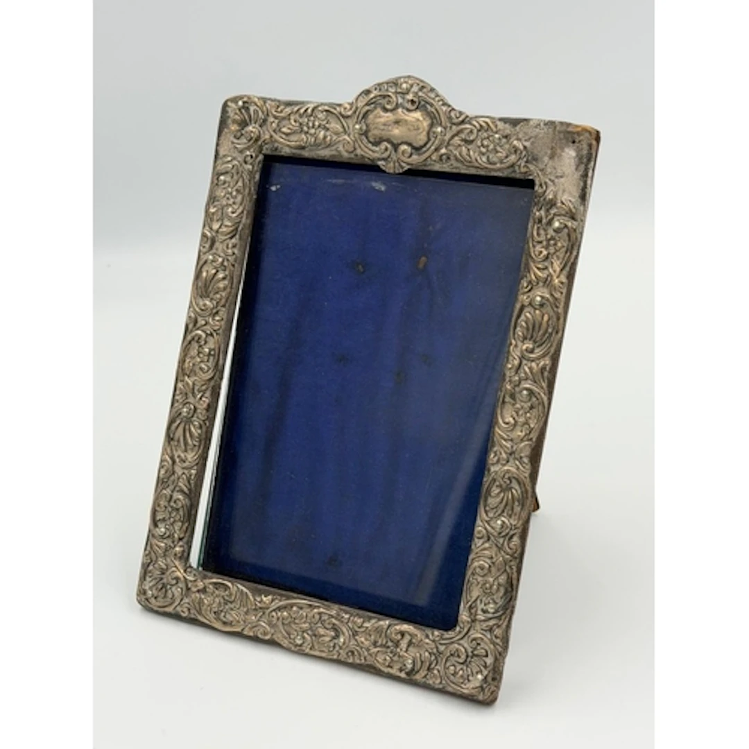 A silver easel backed floriate decorated picture frame hallm...
