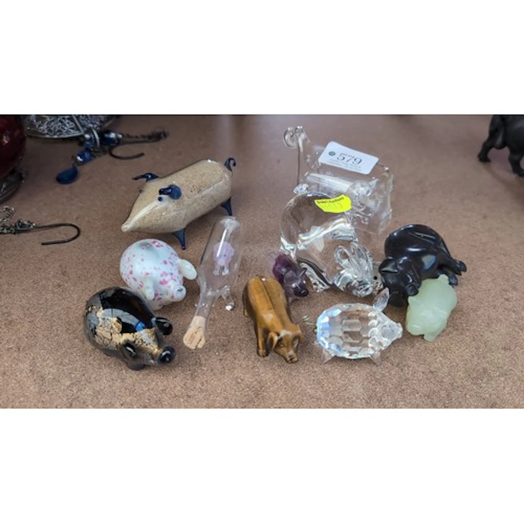 A collection of pig figurines in coloured and clear glass, f...
