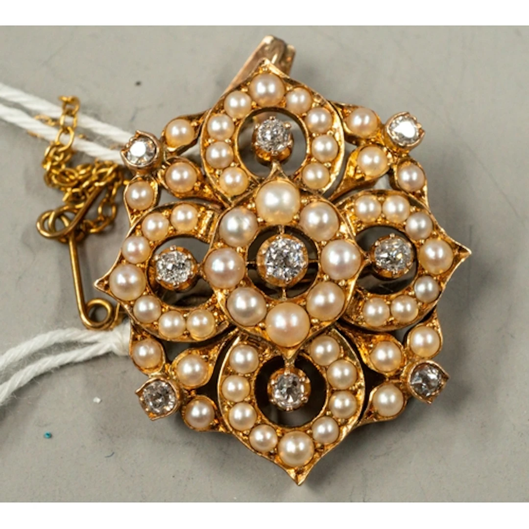 Jewellery: a yellow metal quatrefoil pendant brooch, testing...