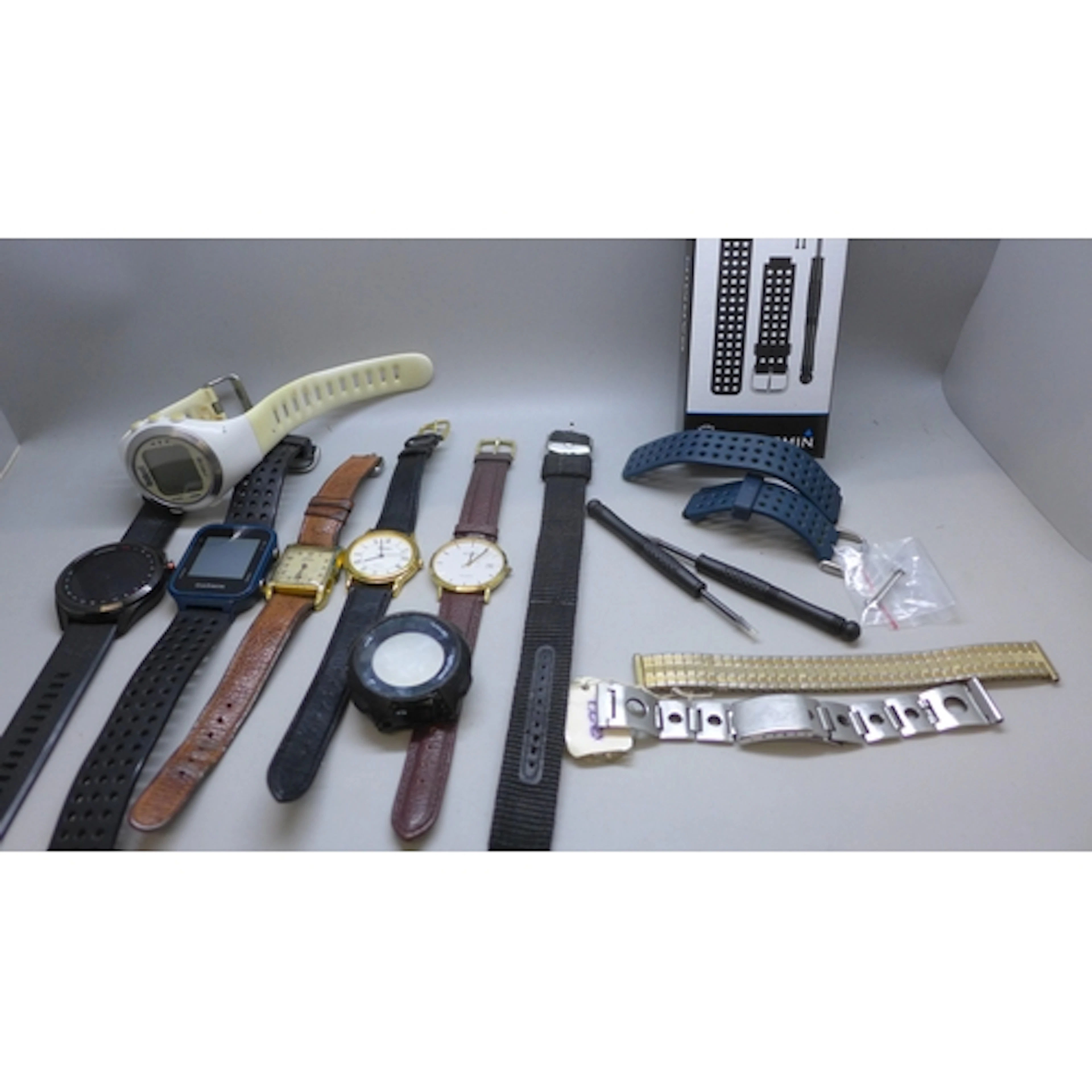 A collection of wristwatches including Garmin sports watches...