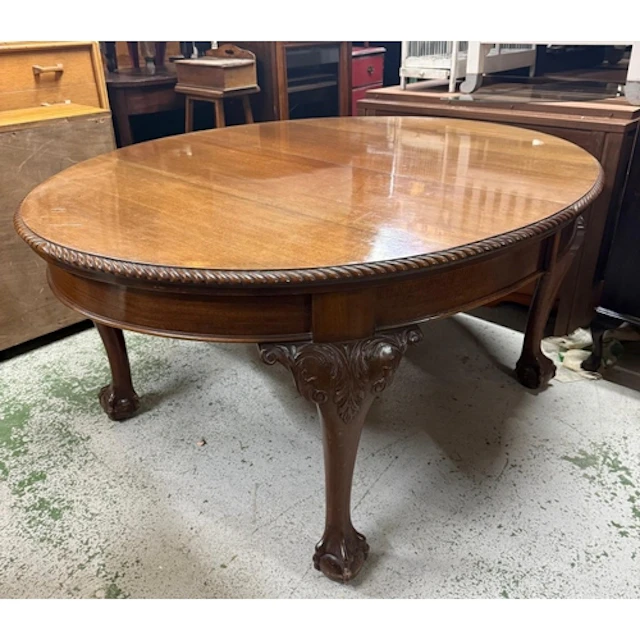 An oval mahogany extendable dining table on claw and ball fe...
