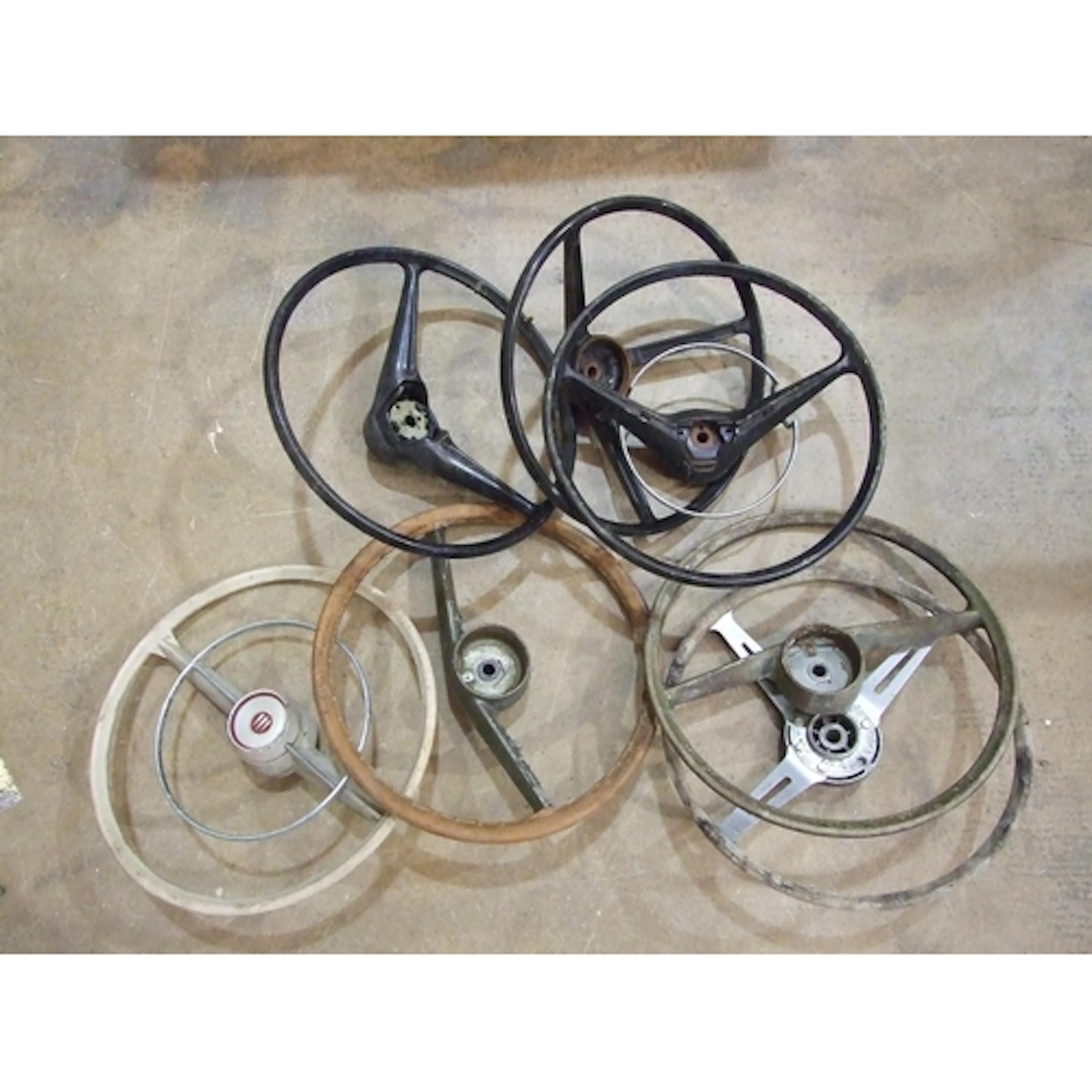 A collection of seven classic car steering wheels, various d...