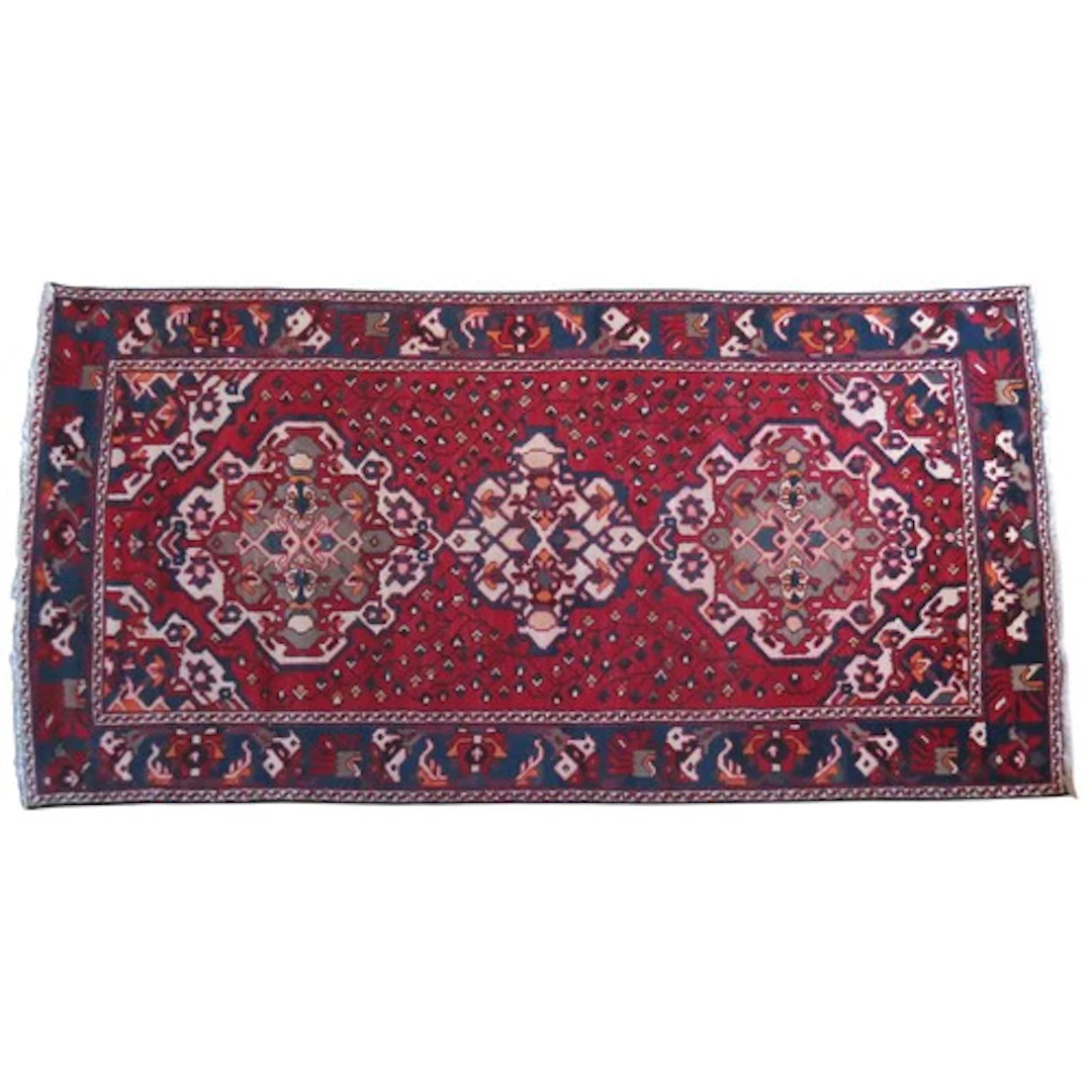A HAND KNOTTED HEREZ RUG deep blue border on a rich red grou...