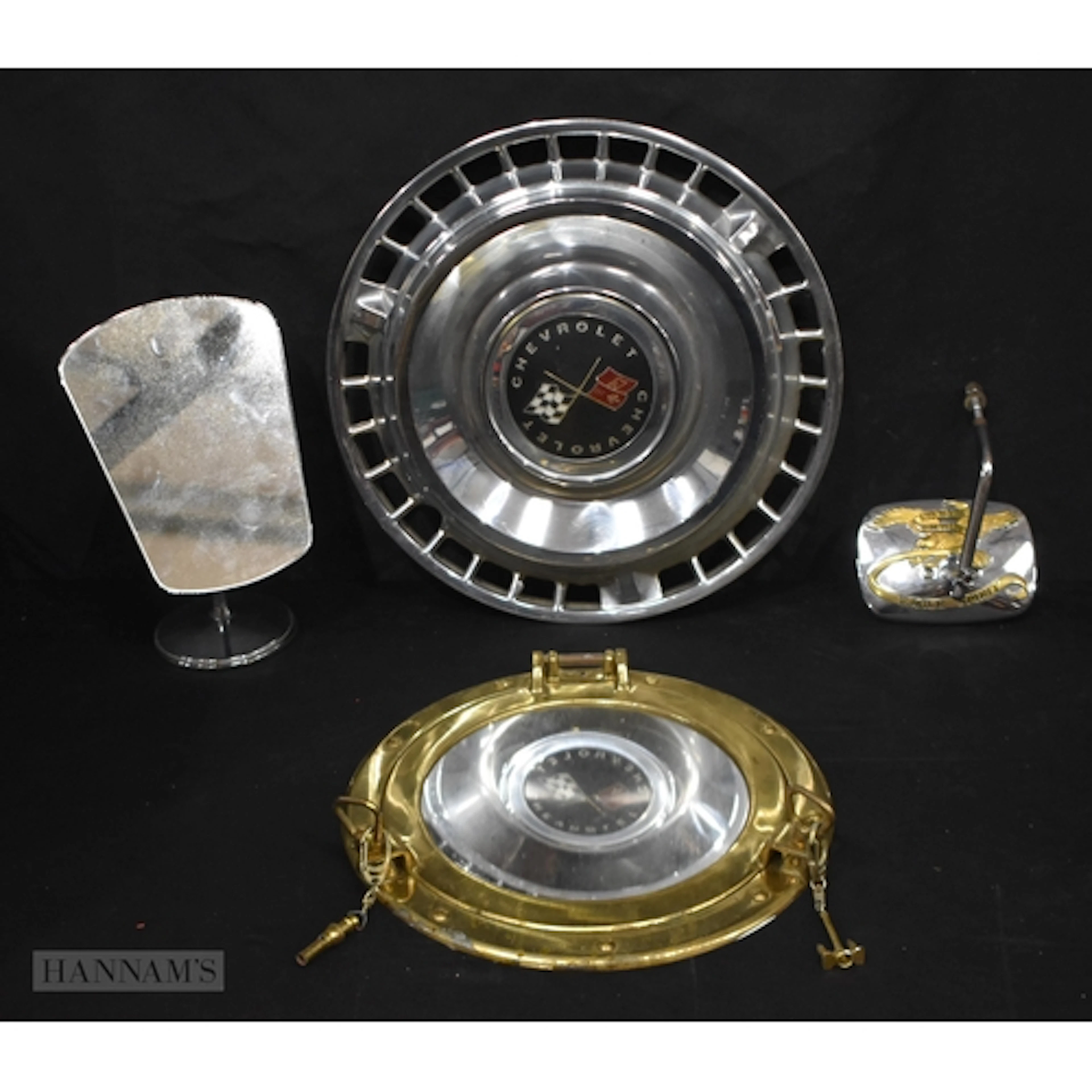 A vintage Chevrolet wheel hub together with a brass porthole...