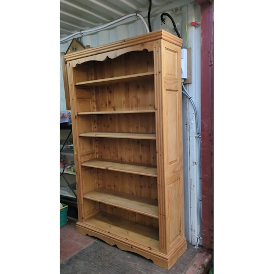 Pine open bookcase with a moulded cornice above a shaped apr...