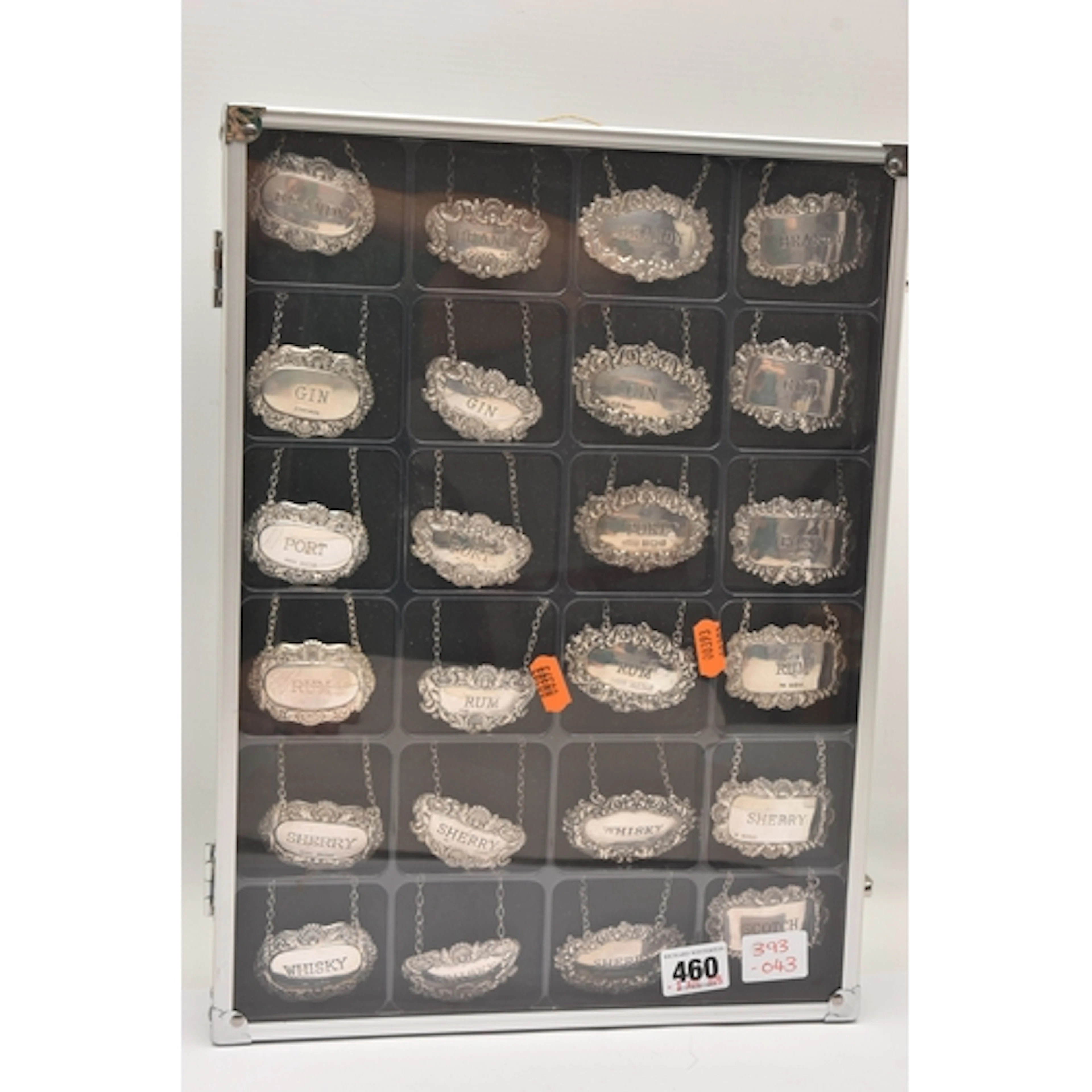 A DISPLAY CASE OF SILVER DECANTER LABELS, to include twenty-...