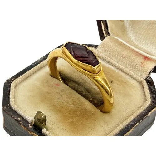 An ancient gold ring set with an elliptical garnet intaglio,...