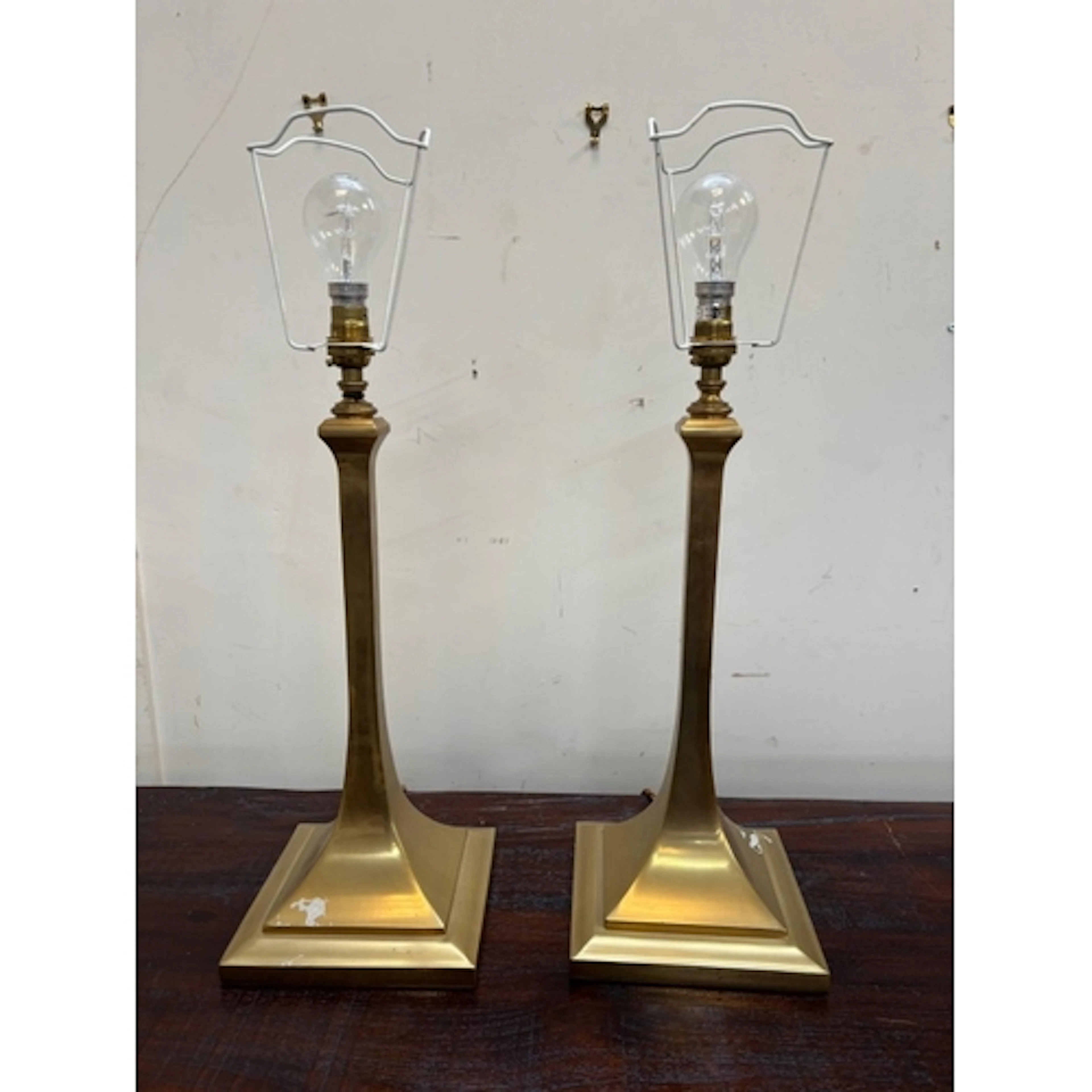 A pair of bras candlestick table lamps on square bases...