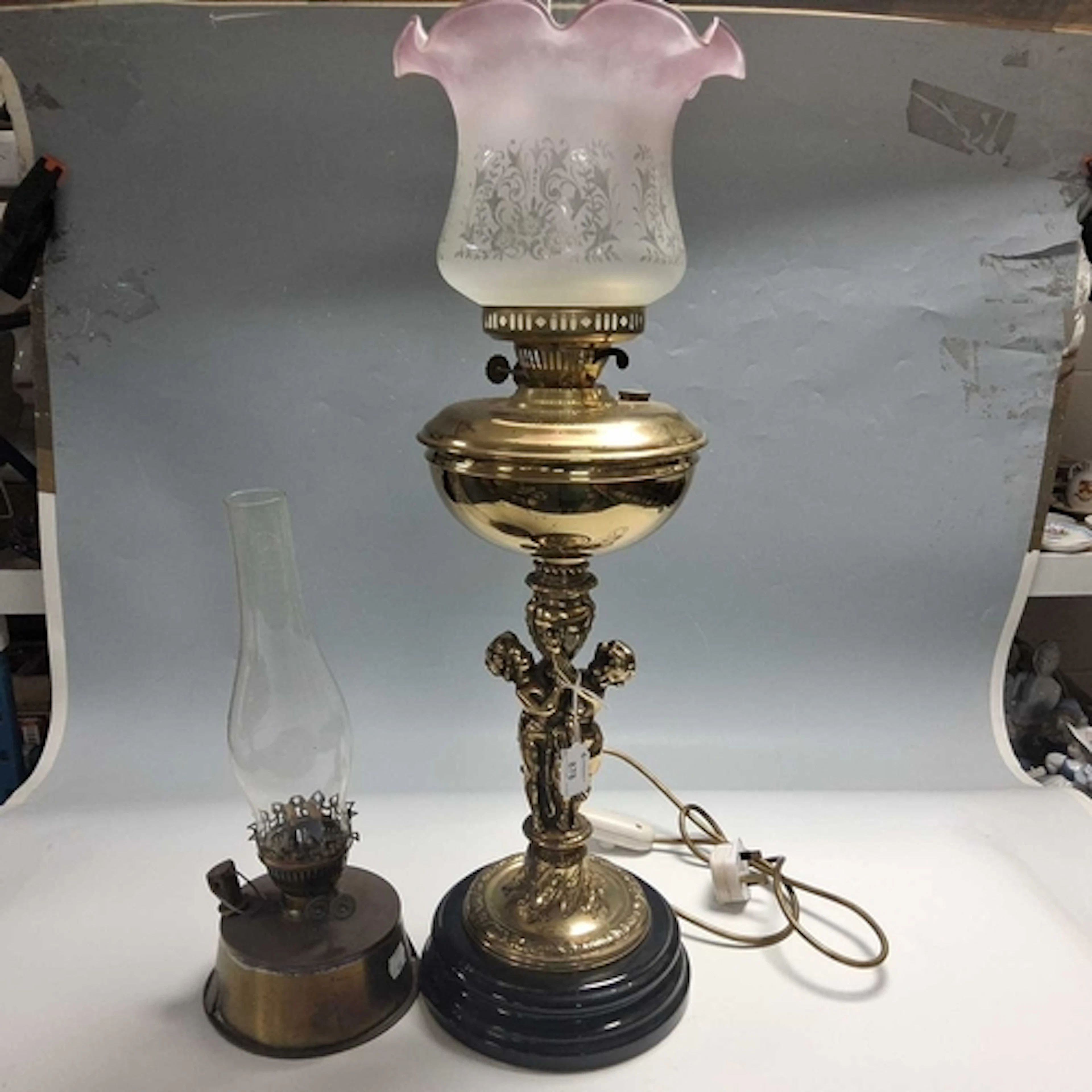 TWO OIL LAMPS comprising a figural style lamp with a brass r...