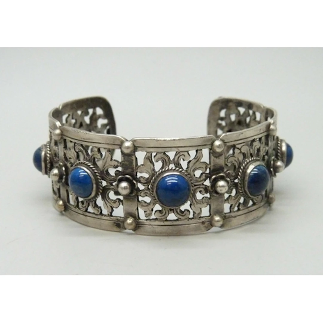 A white metal bangle set with blue cabochon stones, 36g, 6 x...