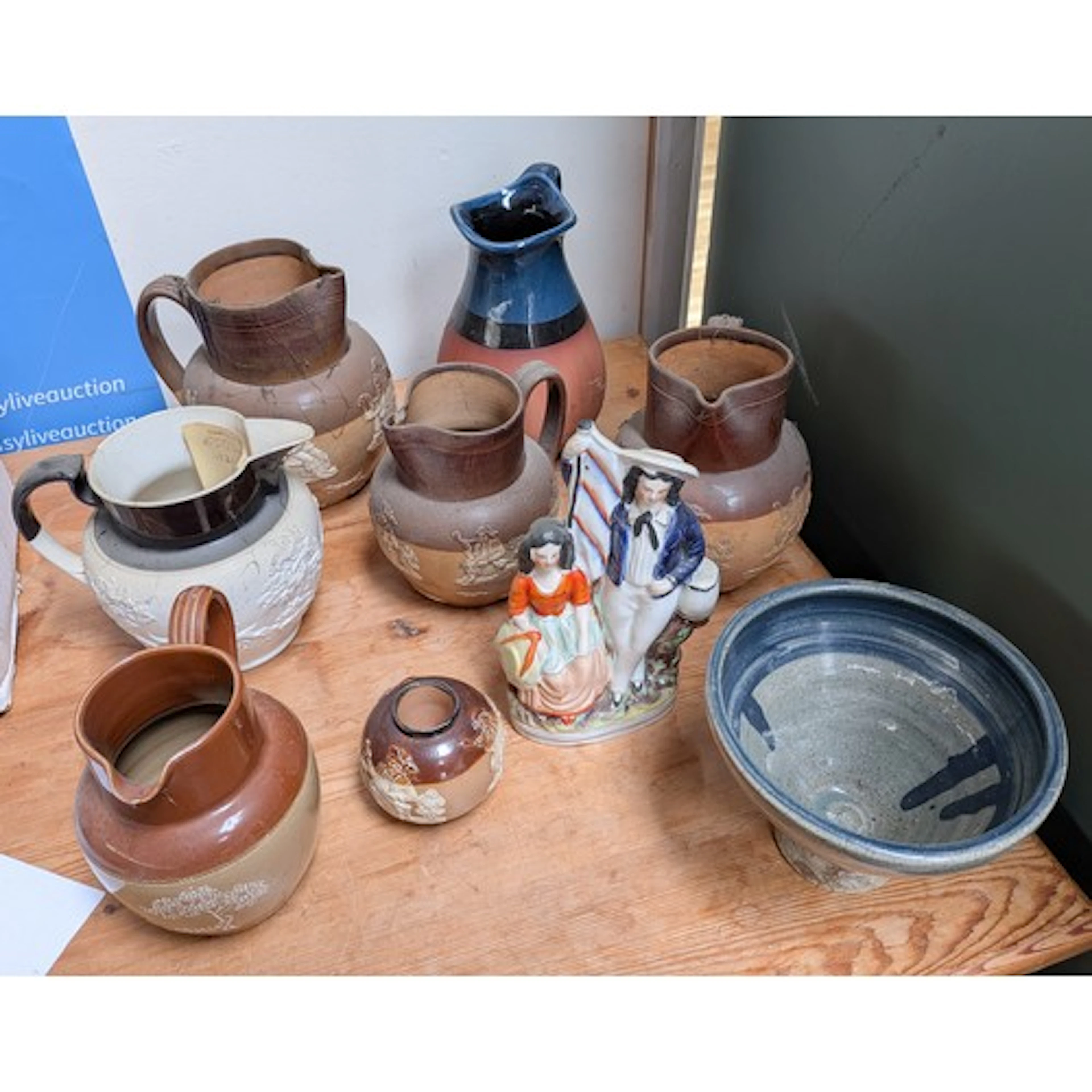 Three graduating Doulton stoneware jugs, Staffordshire figur...