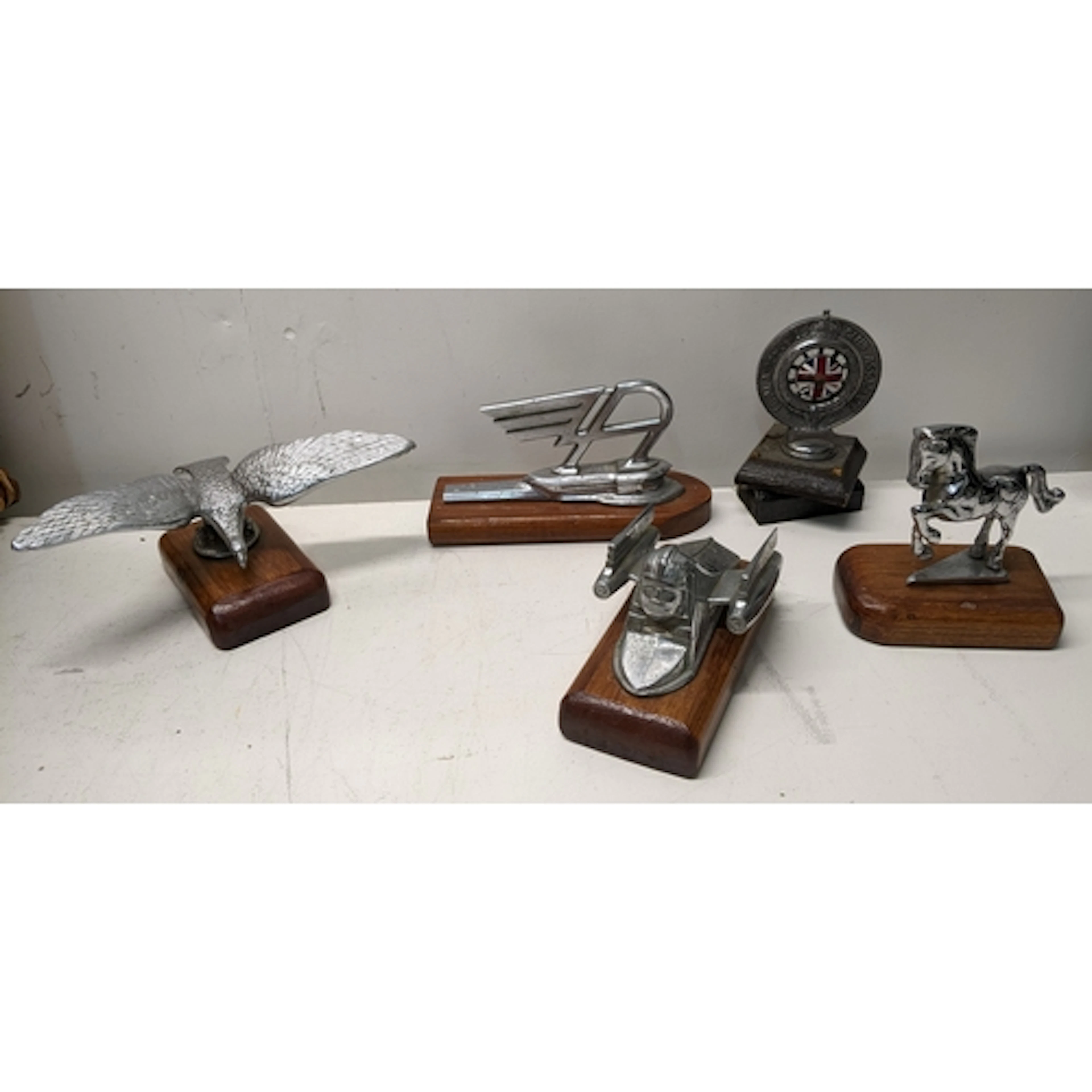A group of early and mid 20th century car mascots, each moun...