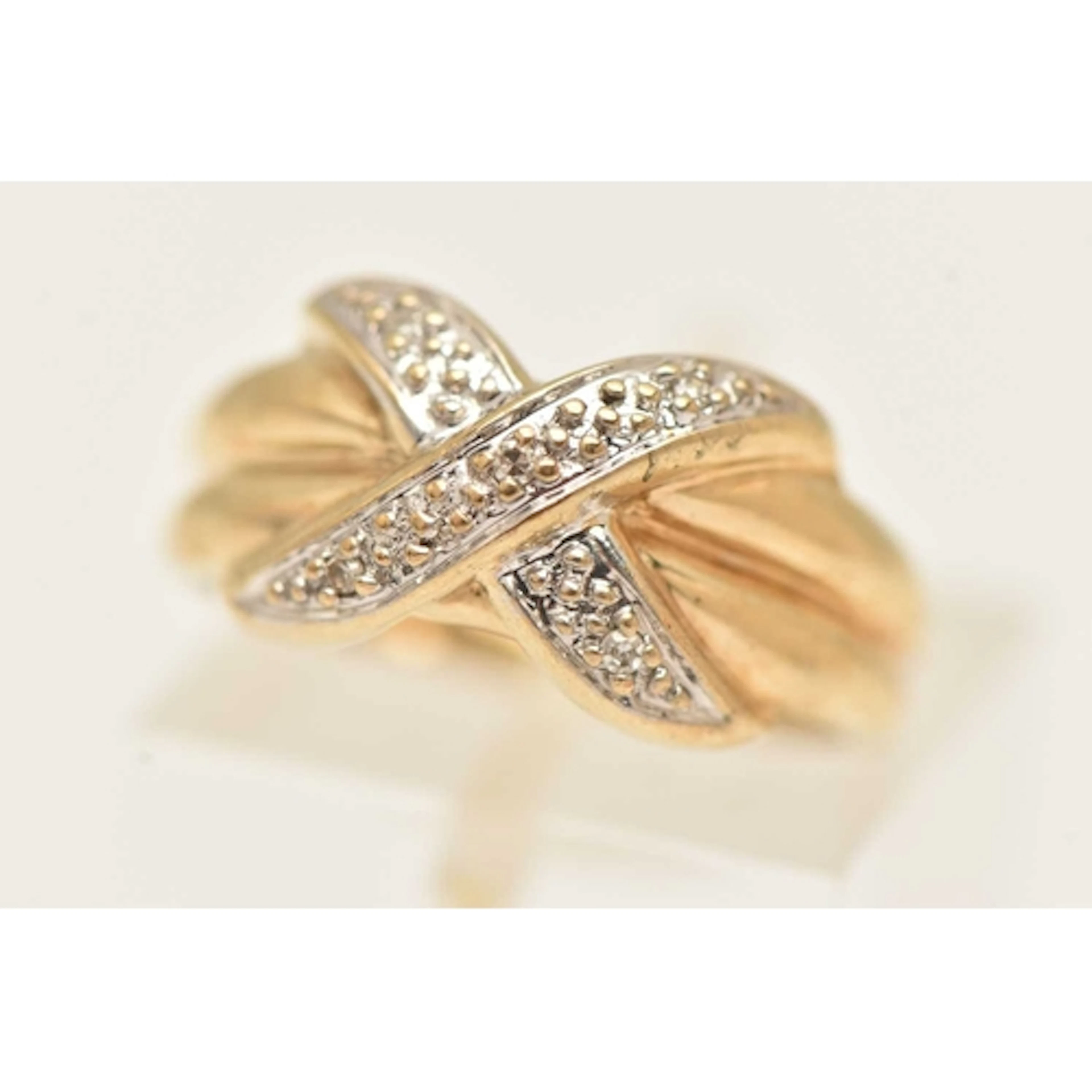 A 9CT GOLD GEM SET RING, designed as a yellow gold cross ove...