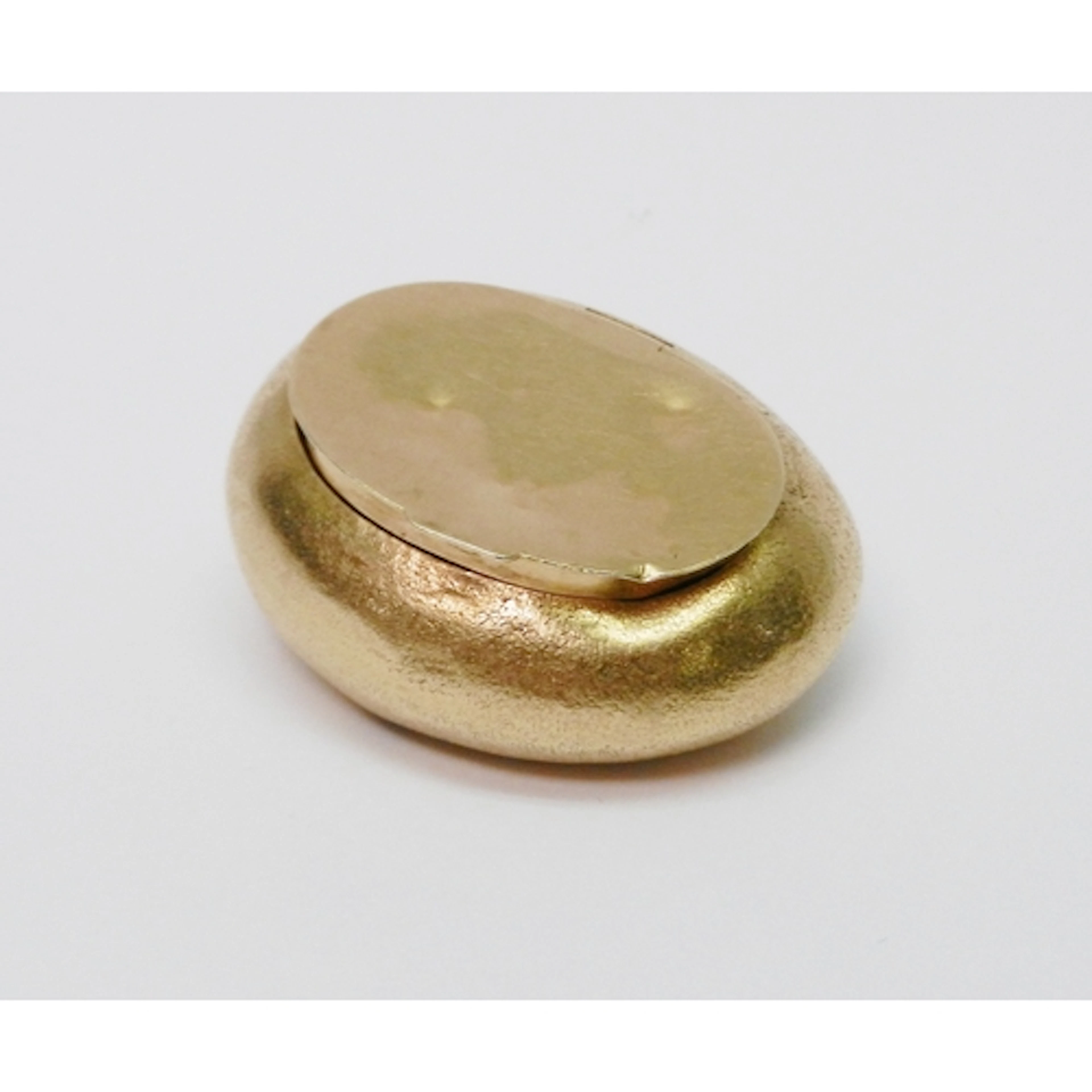 A Pill Box of textured and polished design, yellow metal mar...