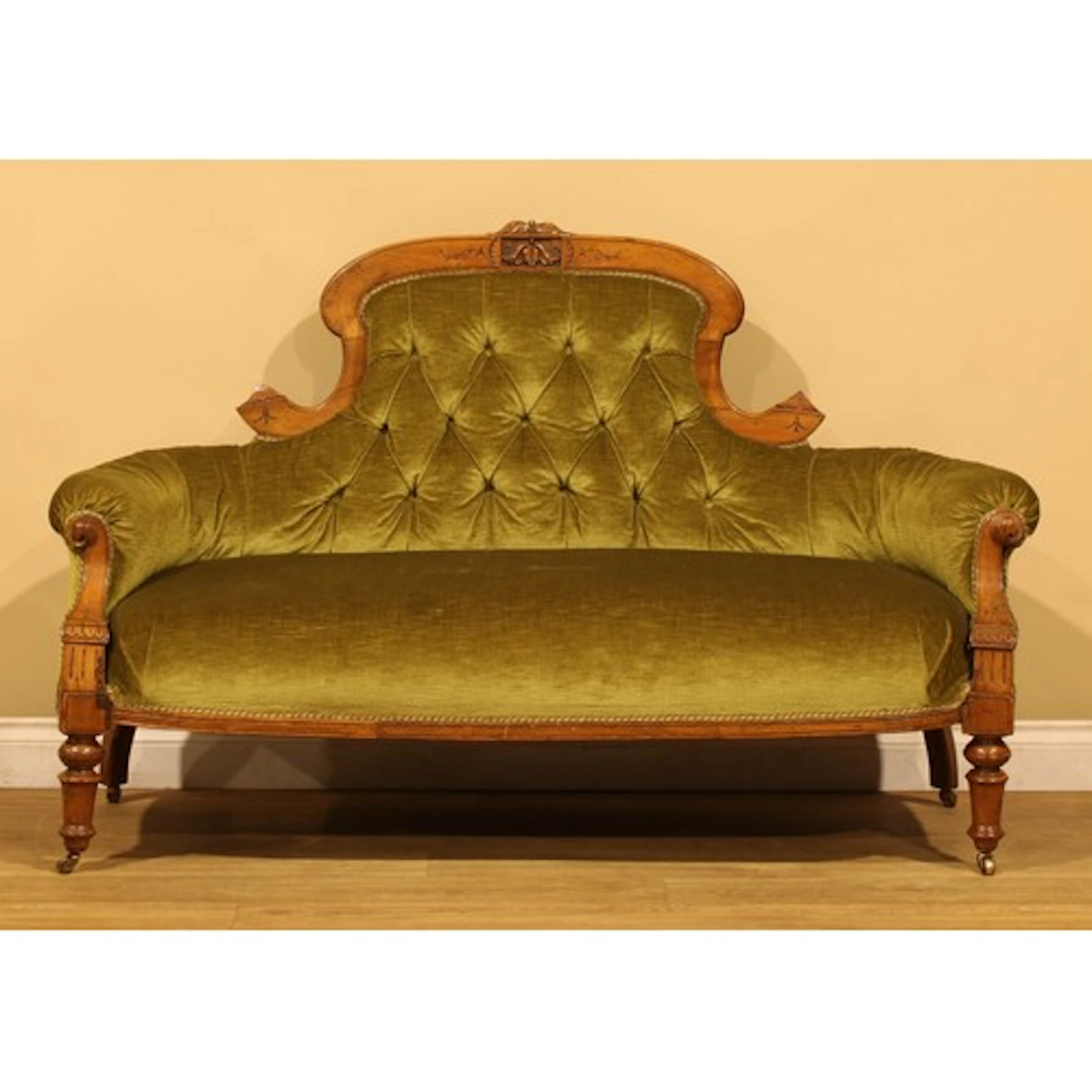A Victorian walnut sofa, stuffed-over upholstery, turned for...