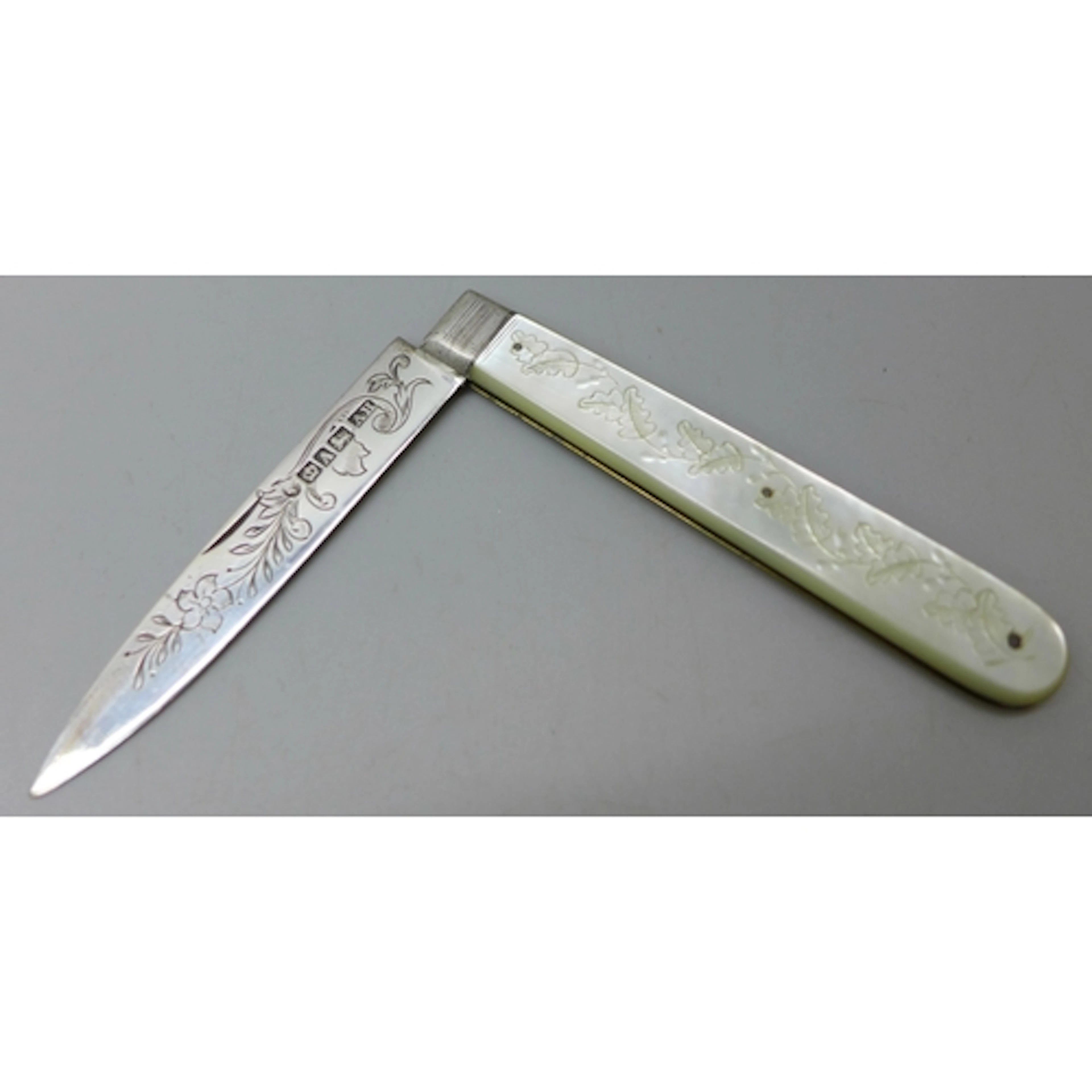 A Victorian carved mother of pearl fruit knife with a silver...