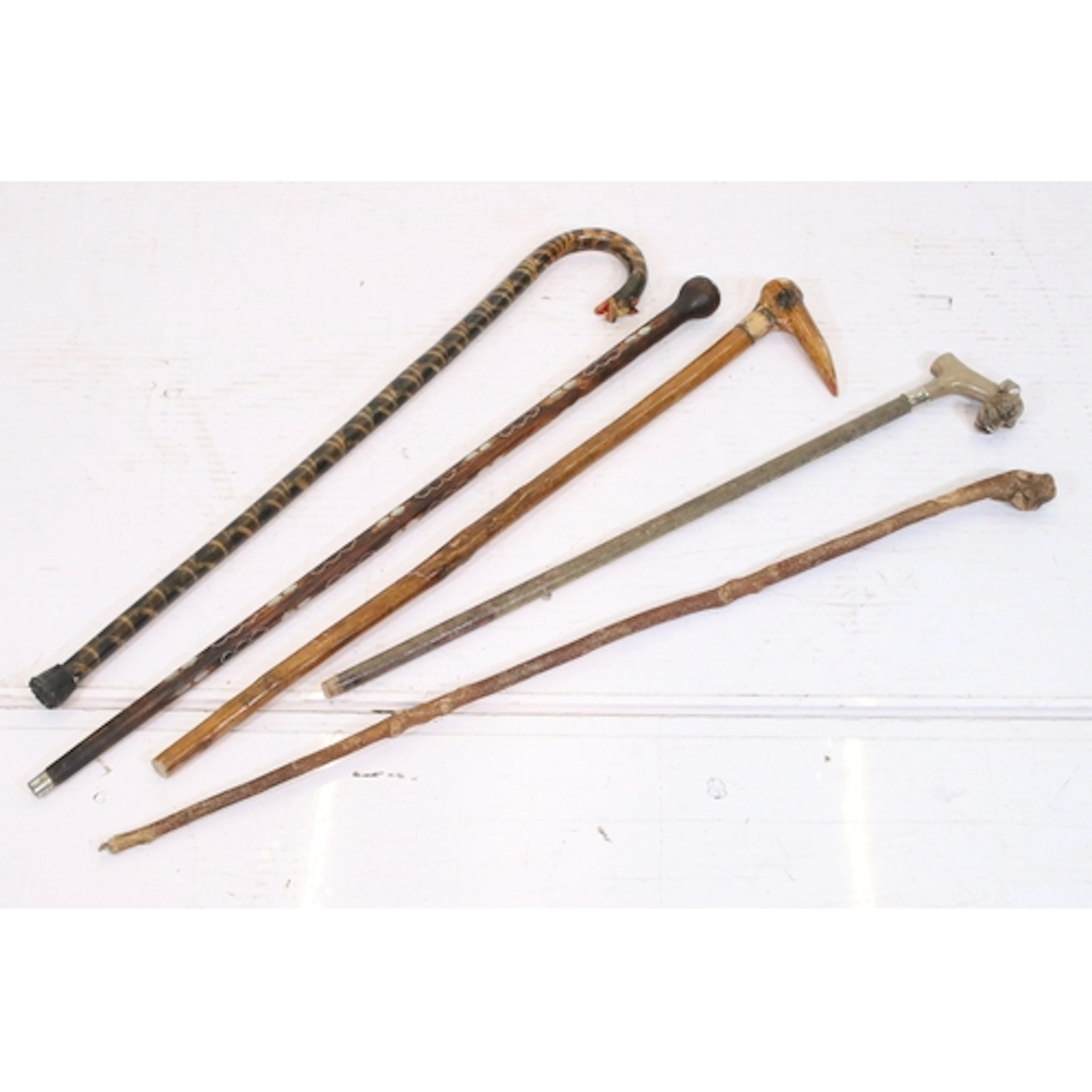 Group of five walking sticks, to comprise three with carved ...