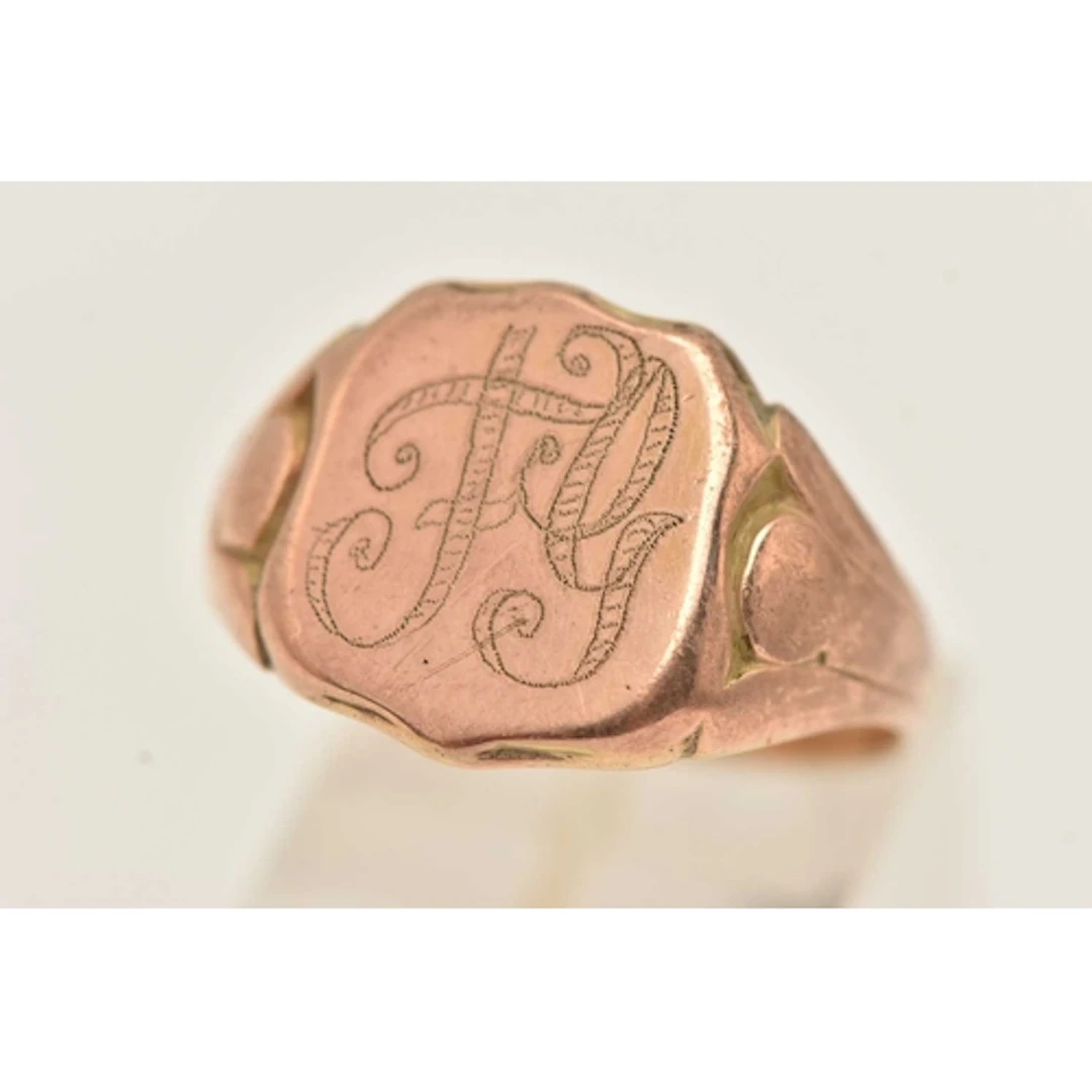 A YELLOW METAL EARLY 20TH CENTURY SIGNET RING, The shield sh...