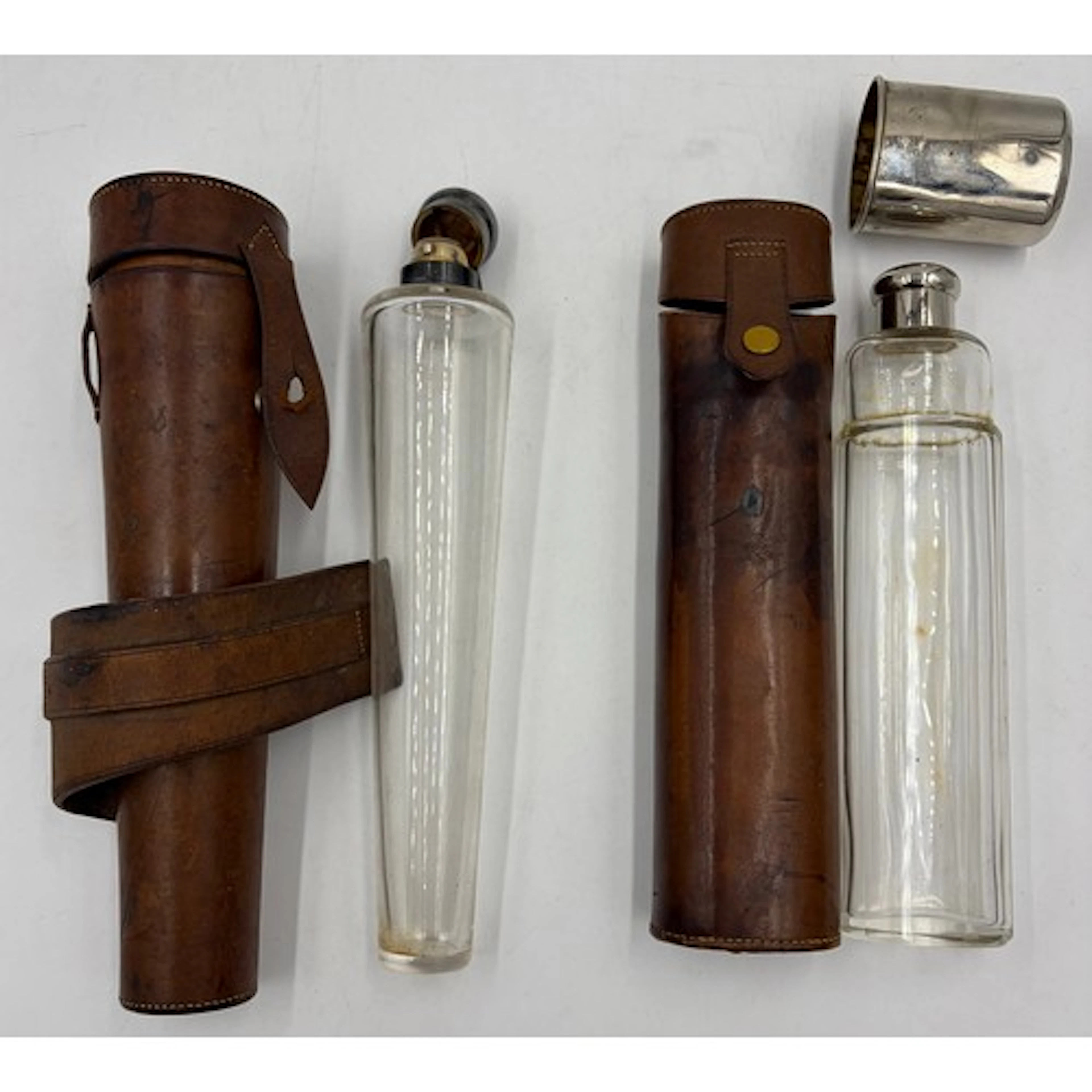 Two glass hunting flasks, with chrome-coloured caps and hous...
