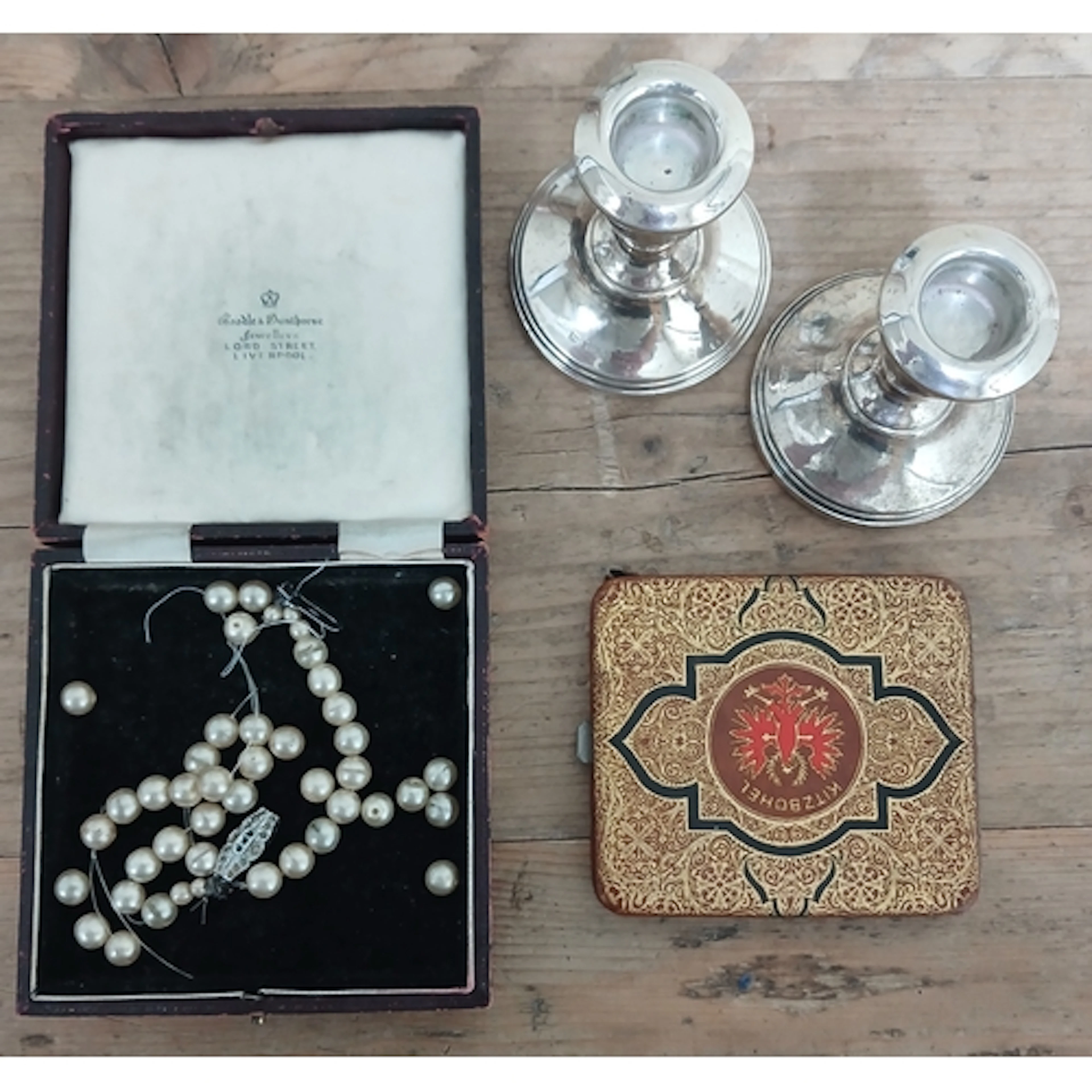 A pair of hallmarked silver candlesticks, a Boodle and Dunth...