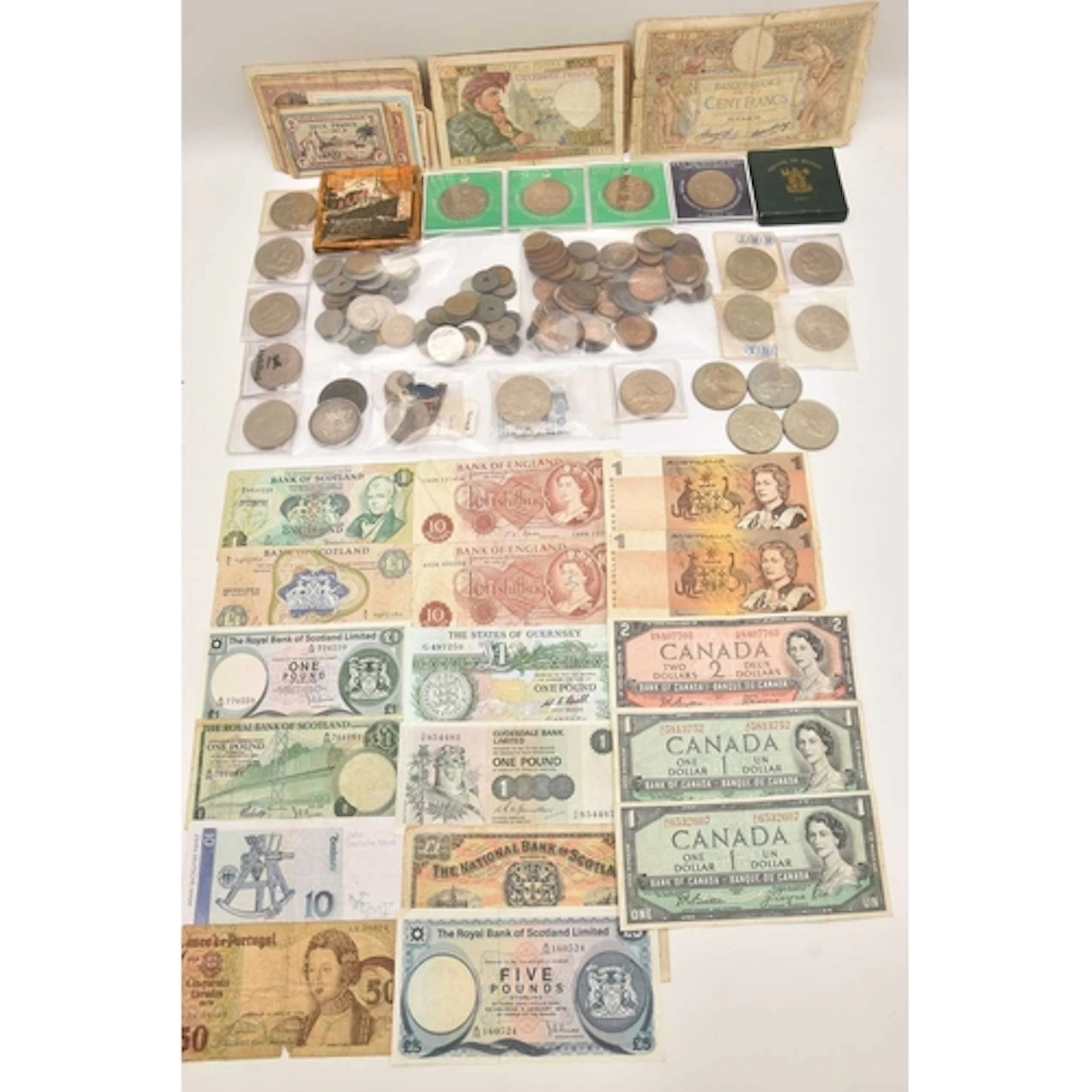 A cardboard box containing mixed coins and banknotes, includ...