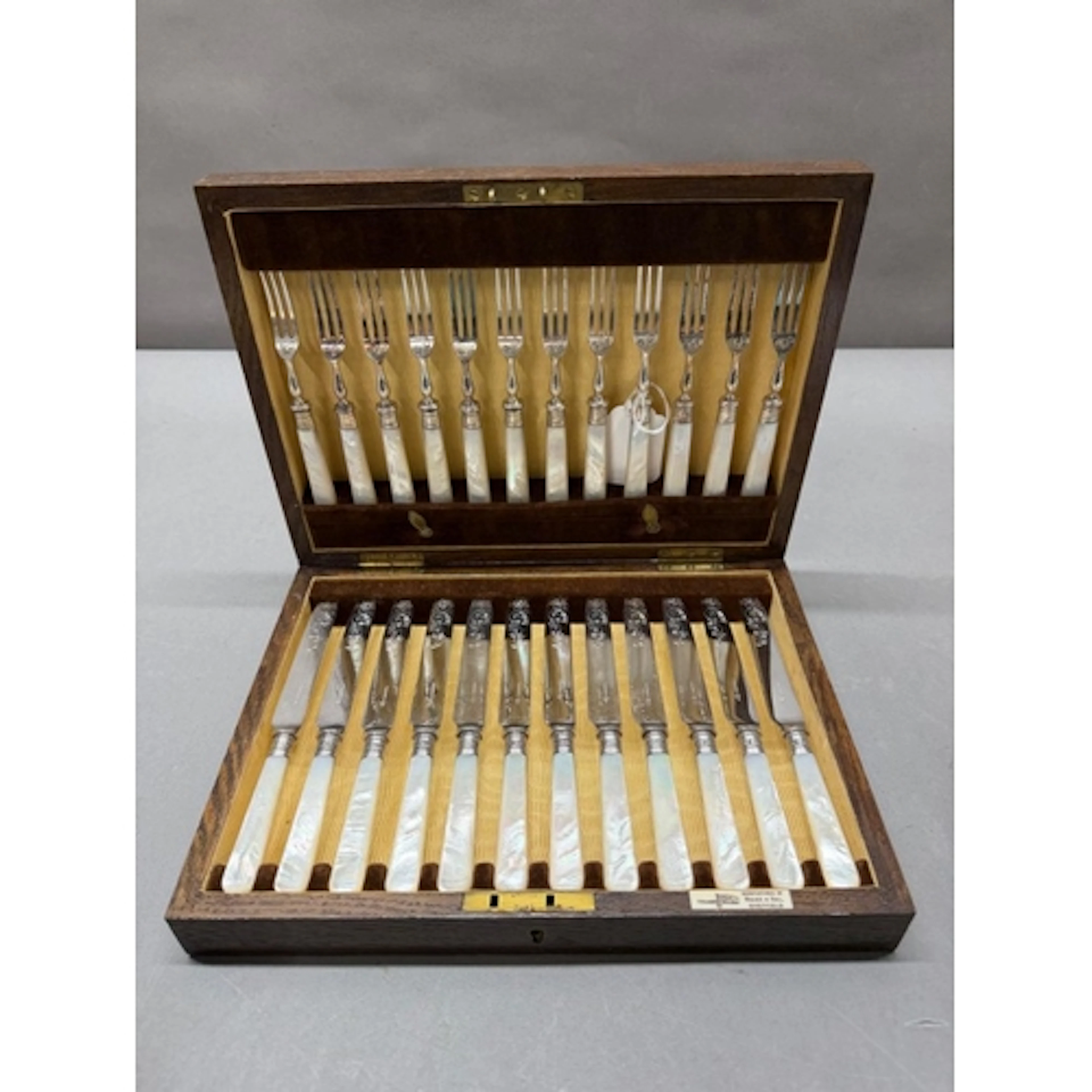 A twelve place setting fruit knife and fork set with mother...