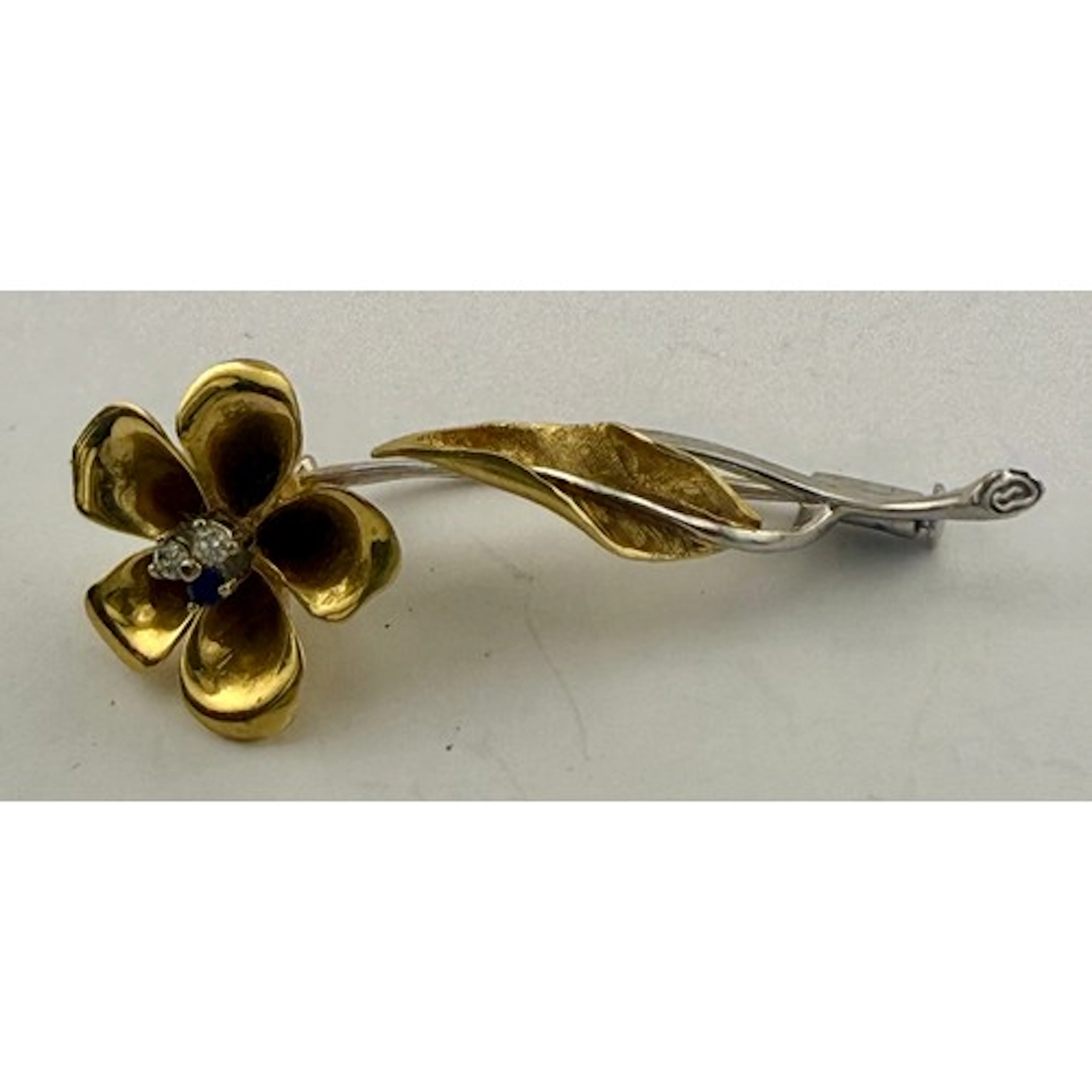 An 18 carat yellow and white gold brooch in the form of a fl...