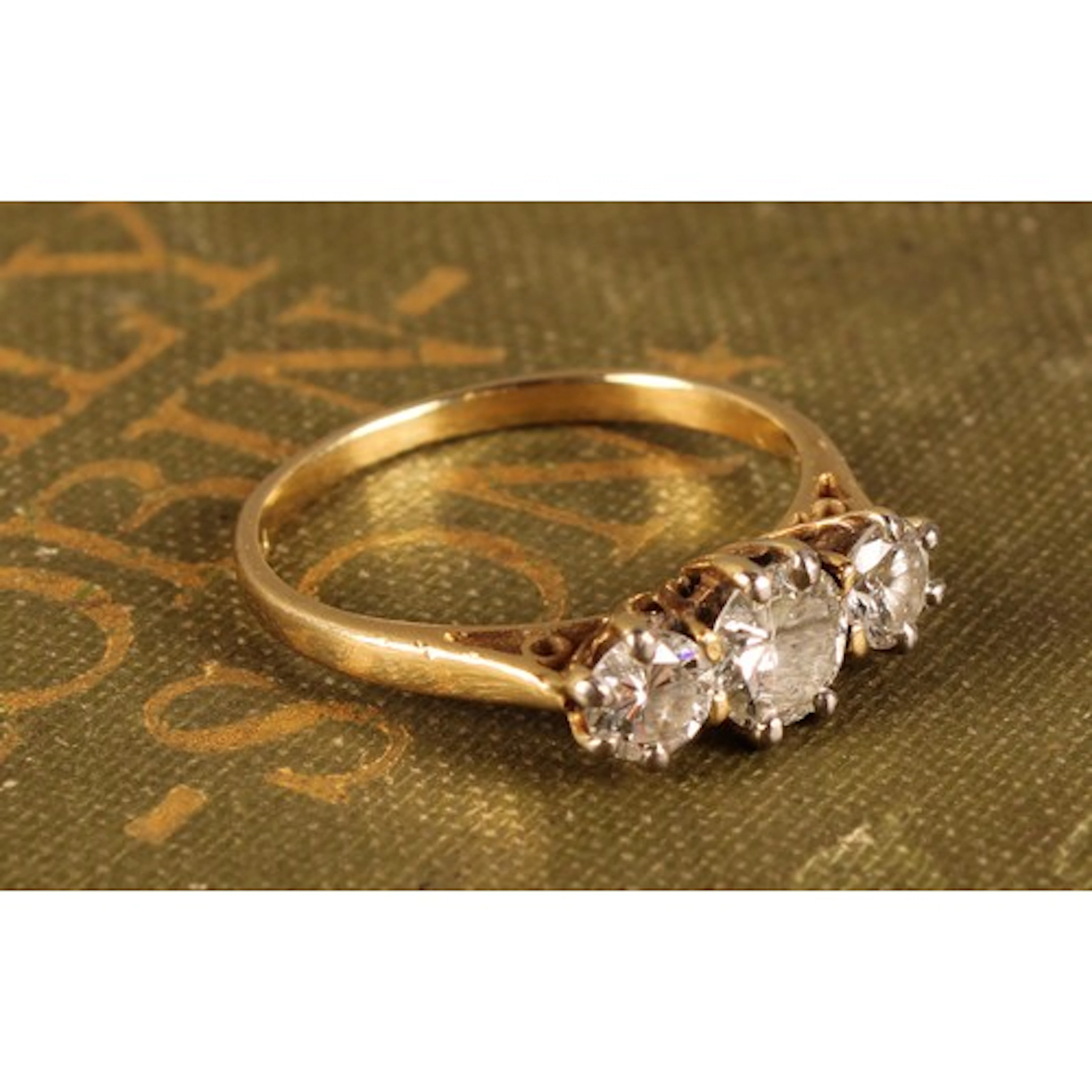 A diamond trilogy ring, central round brilliant cut diamond ...