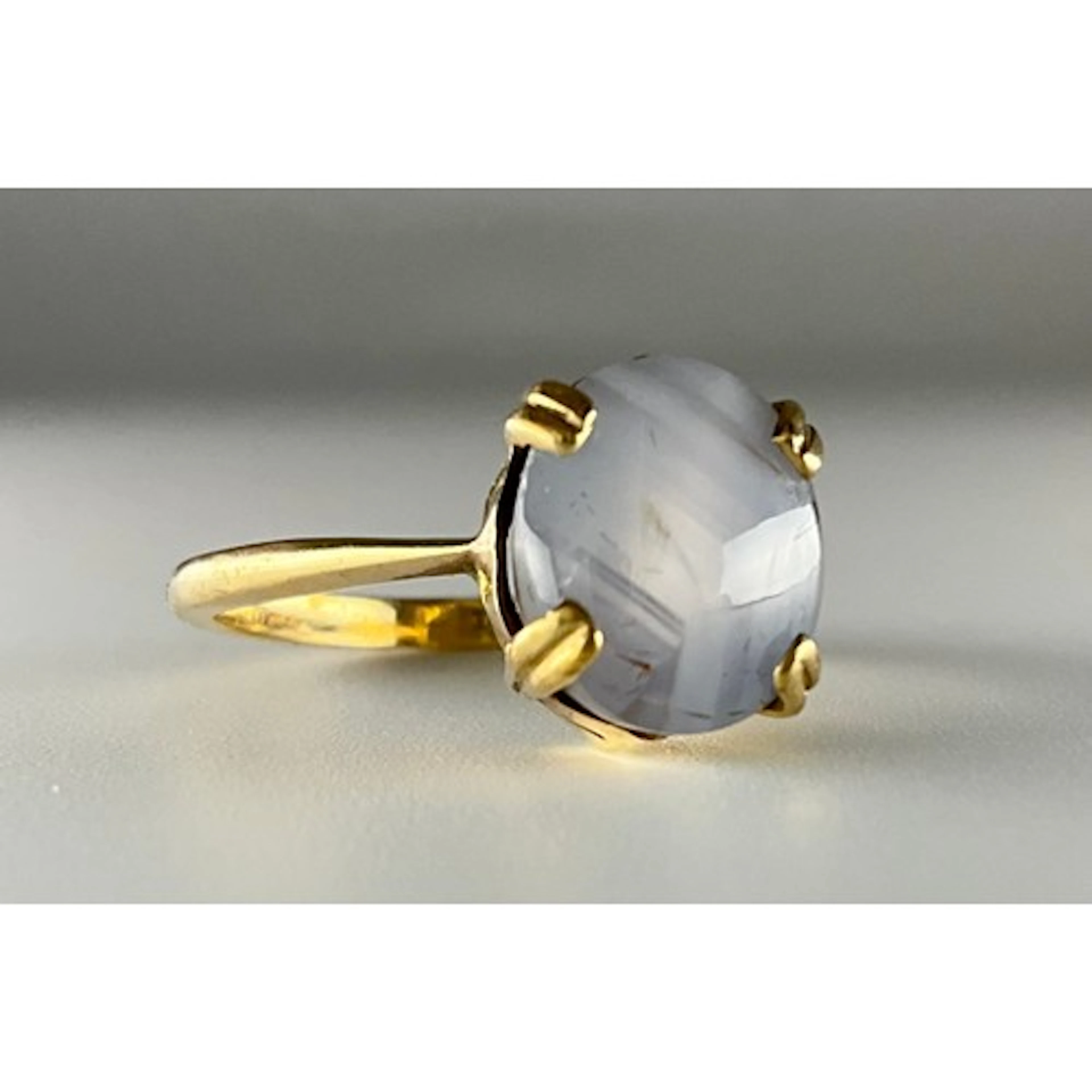 A 9ct gold natural star sapphire ring, set with an oval cabo...