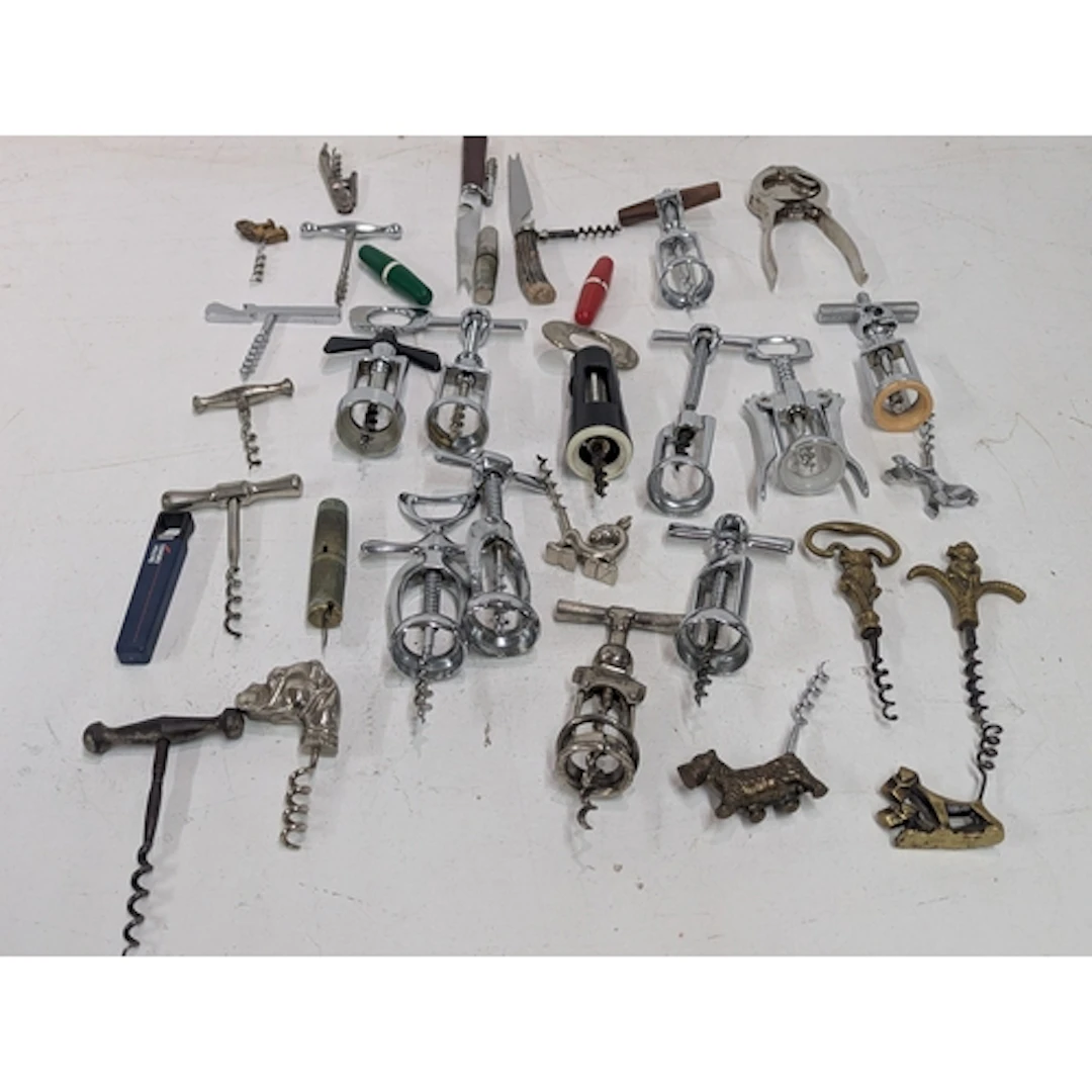 A collection of vintage corkscrews and bottle openers, mainl...