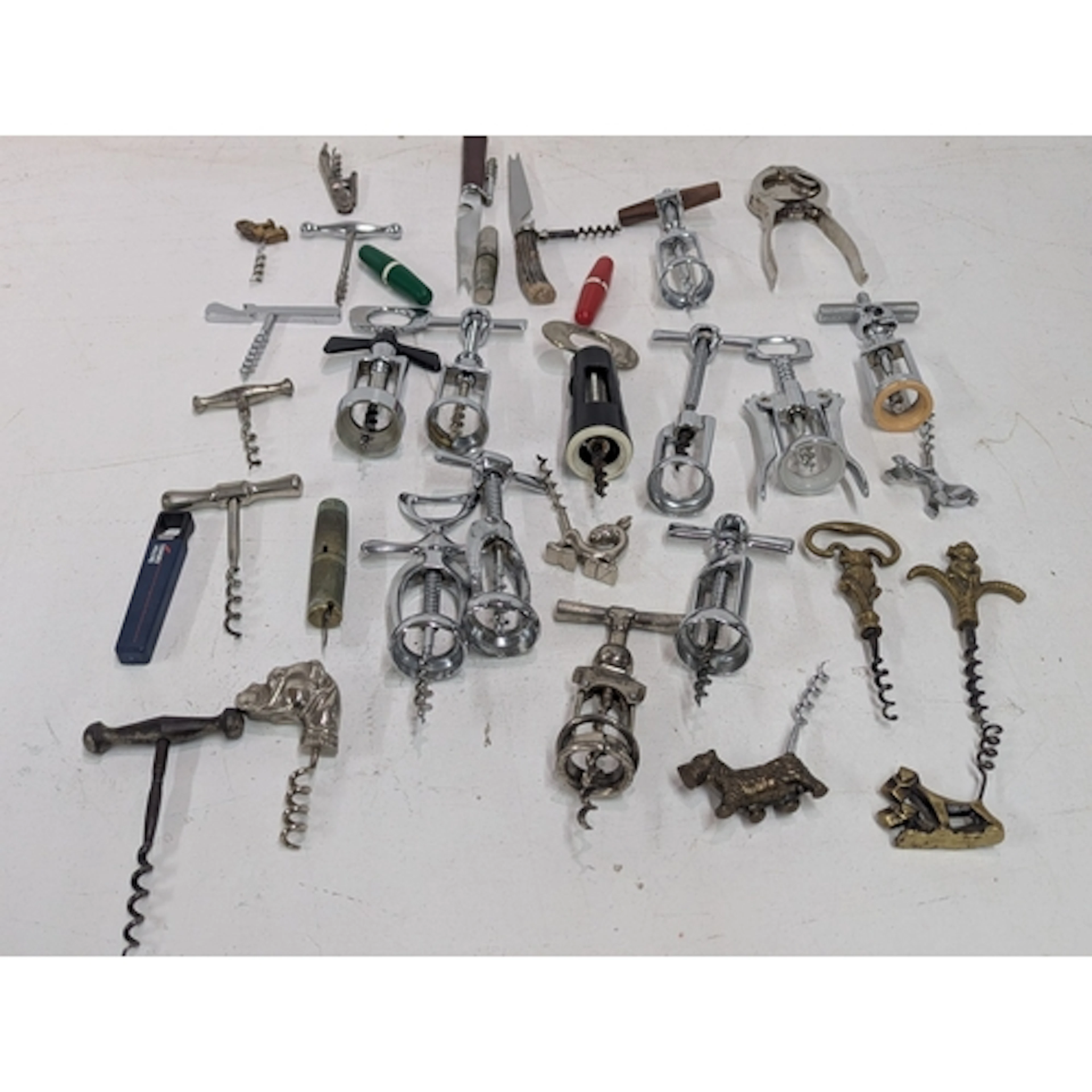 A collection of vintage corkscrews and bottle openers, mainl...