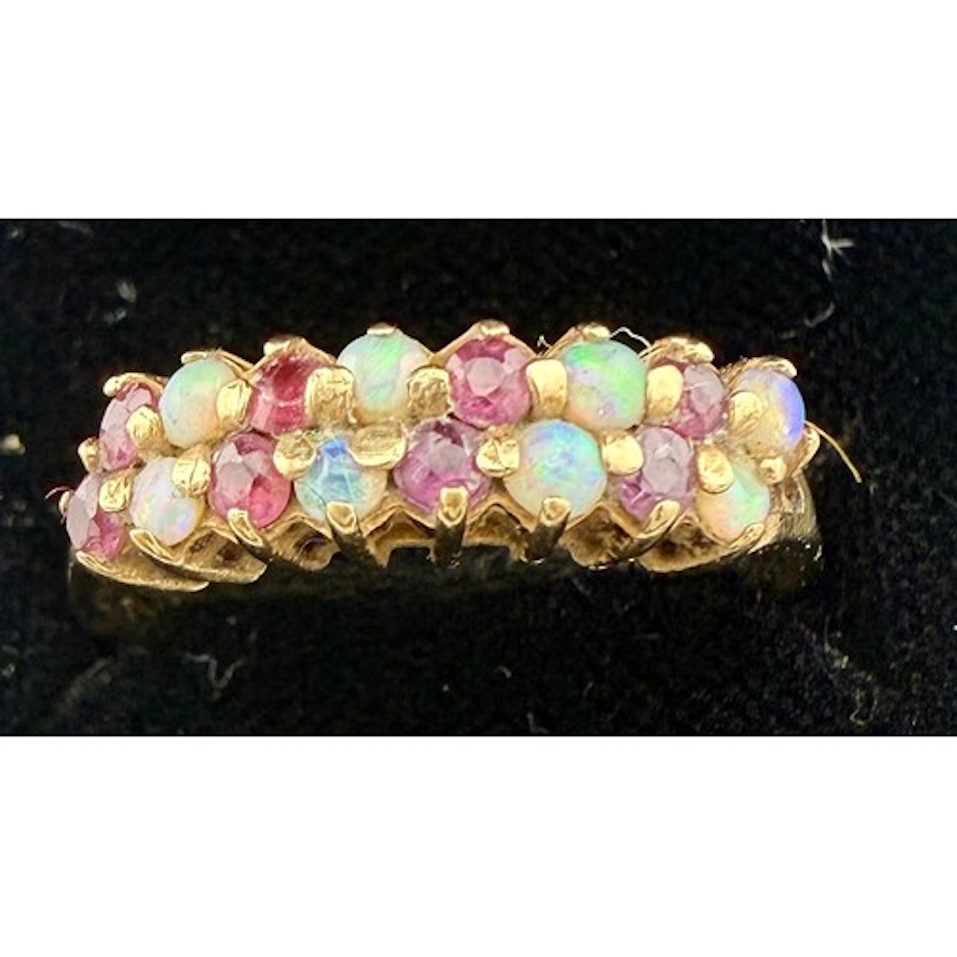 A 9 carat gold ring set with opals and pink stones. Size O, ...