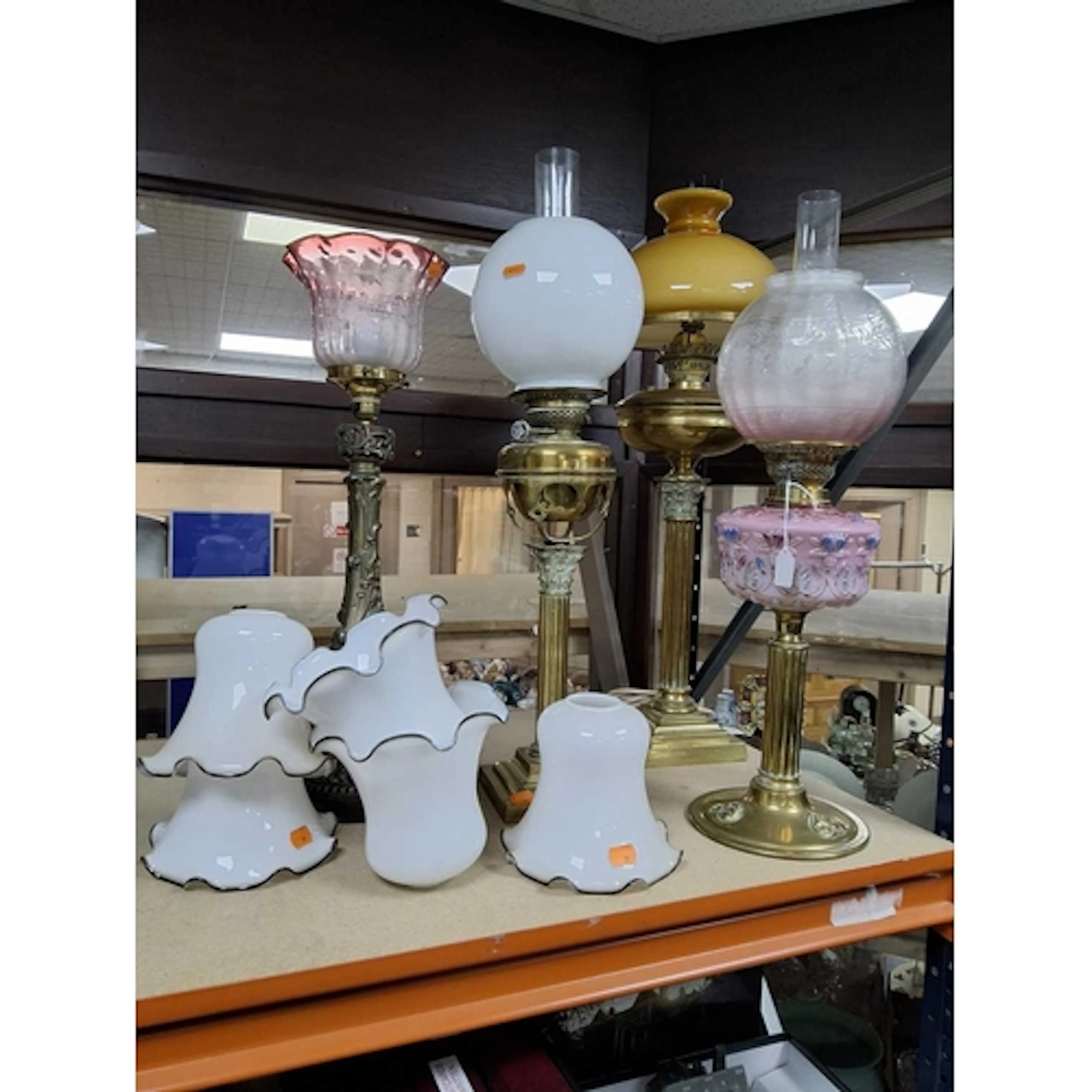 A GROUP OF FOUR BRASS COLUMNED LAMPS, three are oil lamps of...