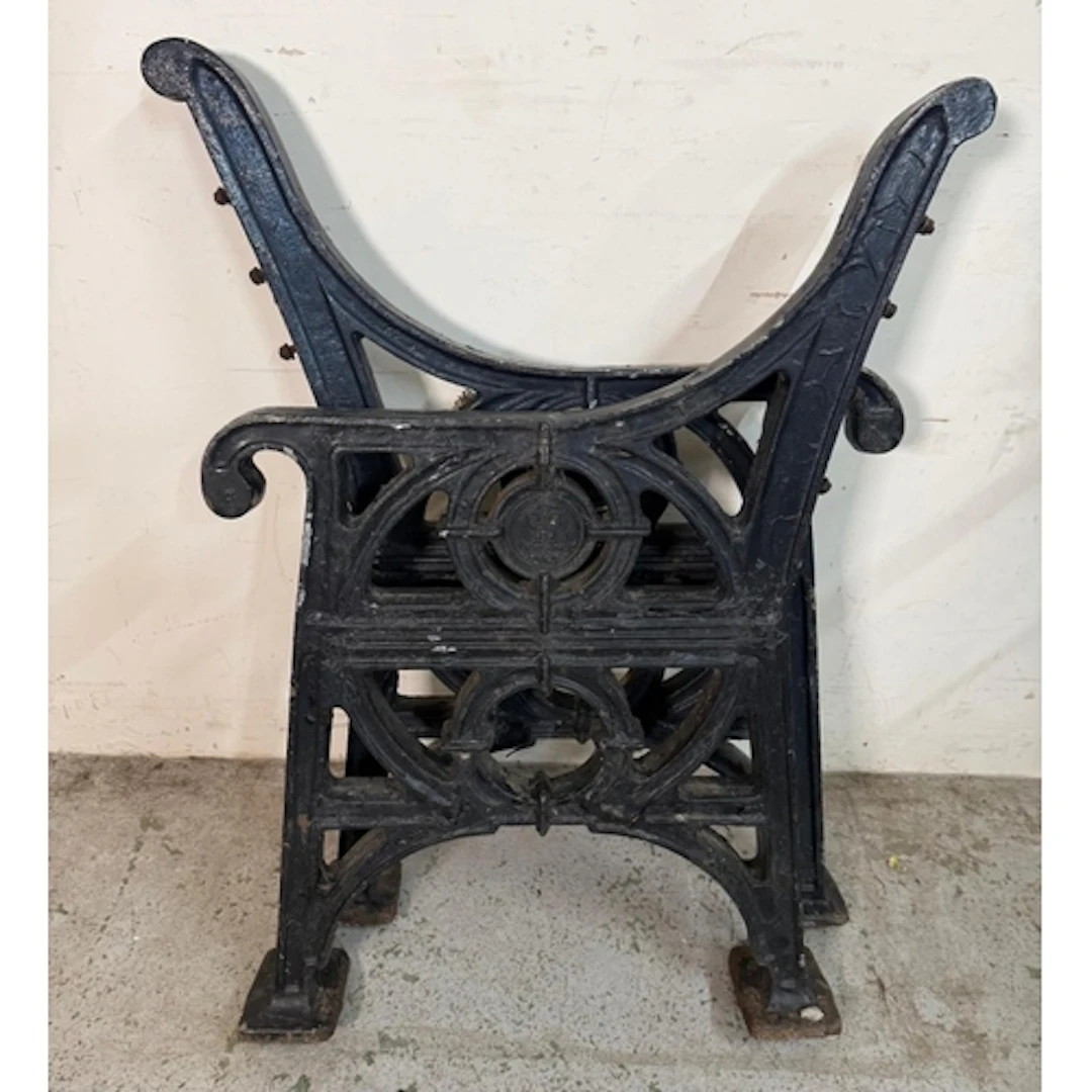 A pair of black painted cast iron bench ends featuring the R...