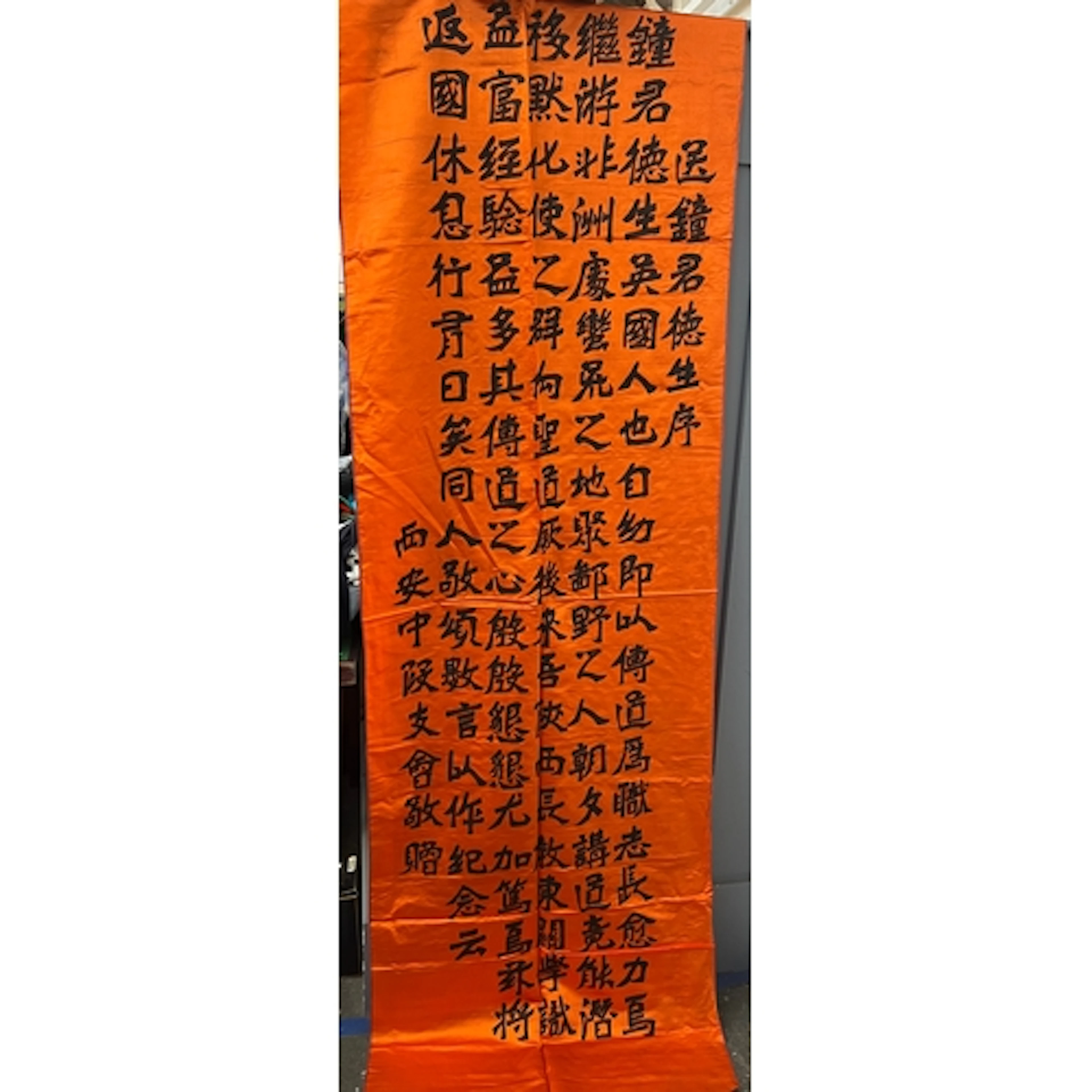 An early 20th century Chinese orange silk banner with callig...