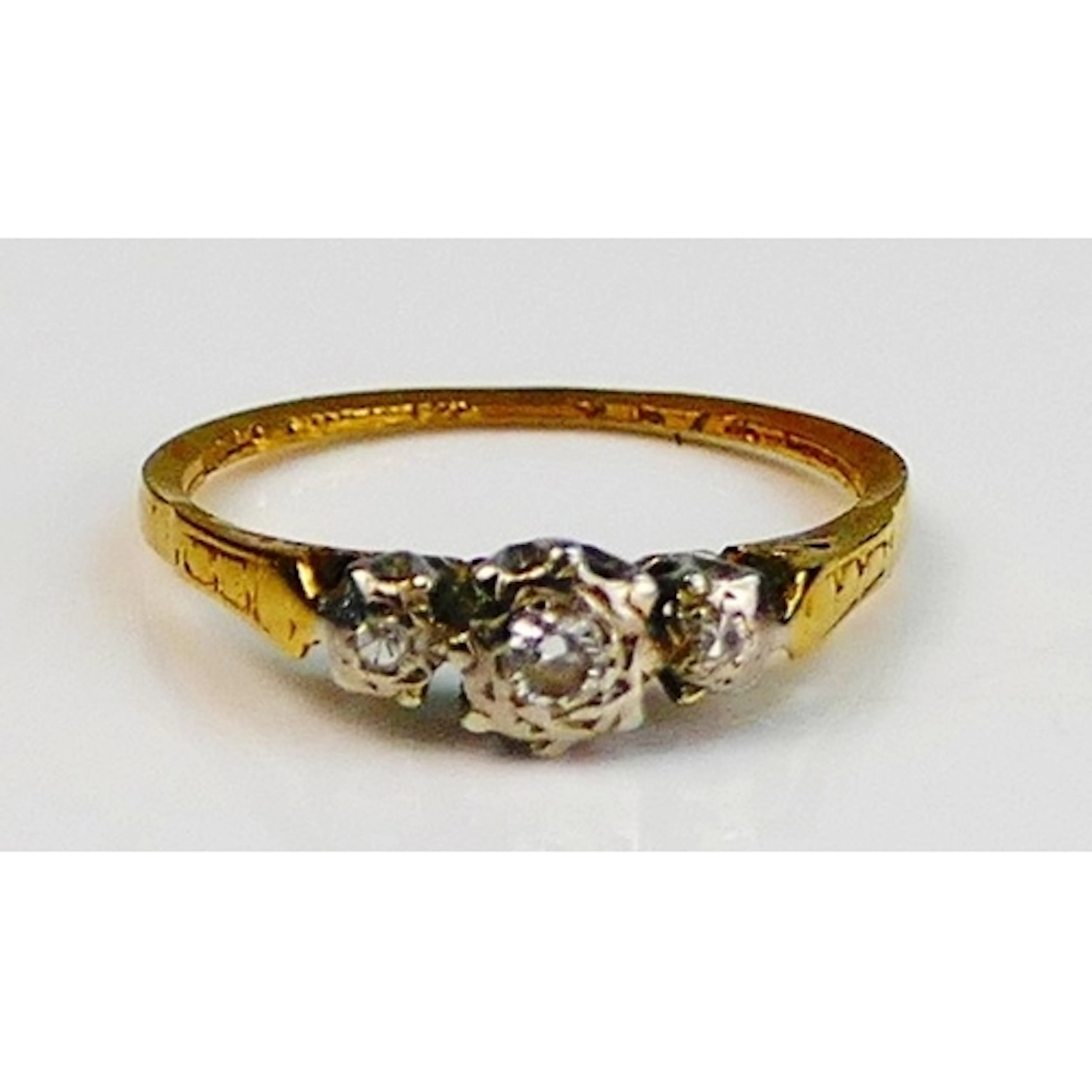 A diamond three stone illusion set ring in a high carat prec...